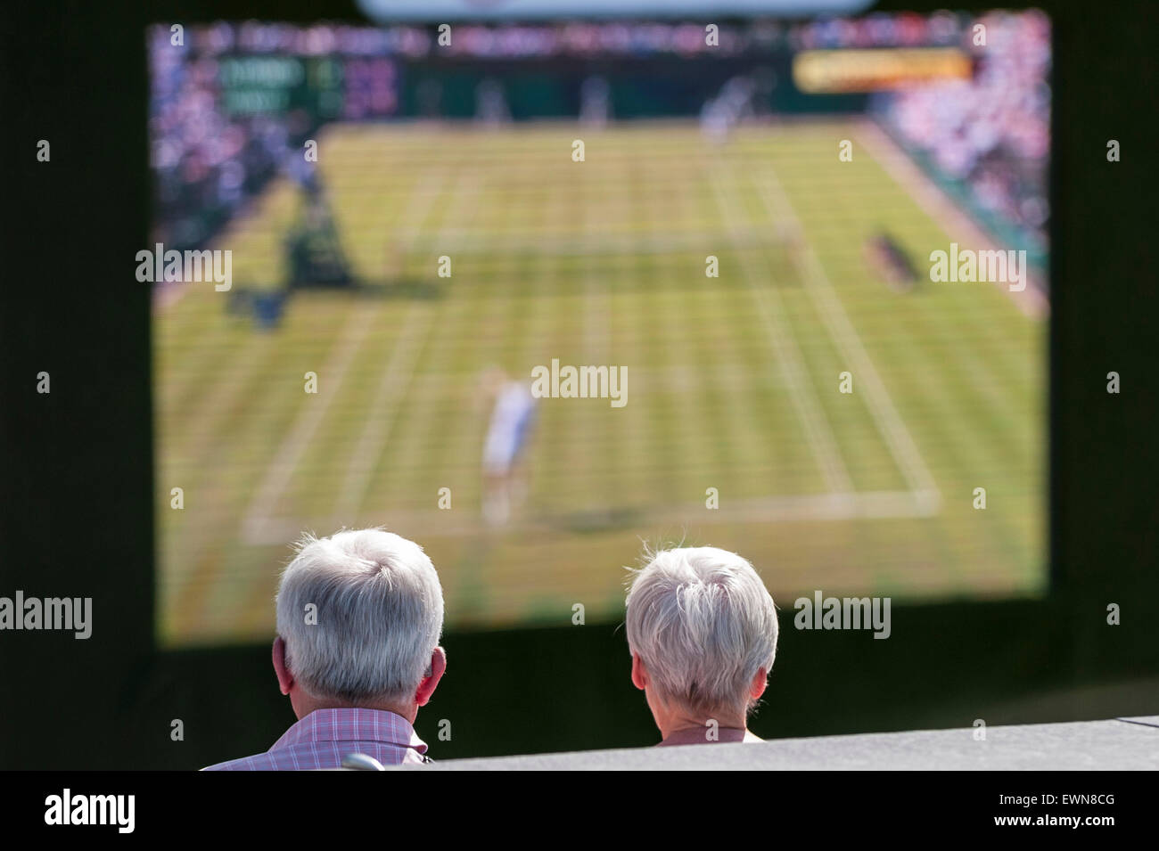 Londres, Royaume-Uni. 29 juin 2015. Un couple regarder le premier jour du tournoi de tennis de Wimbledon en direct diffusée gratuitement sur un écran géant à l'écope, à l'extérieur de l'Hôtel de Ville. Crédit : Stephen Chung / Alamy Live News Banque D'Images
