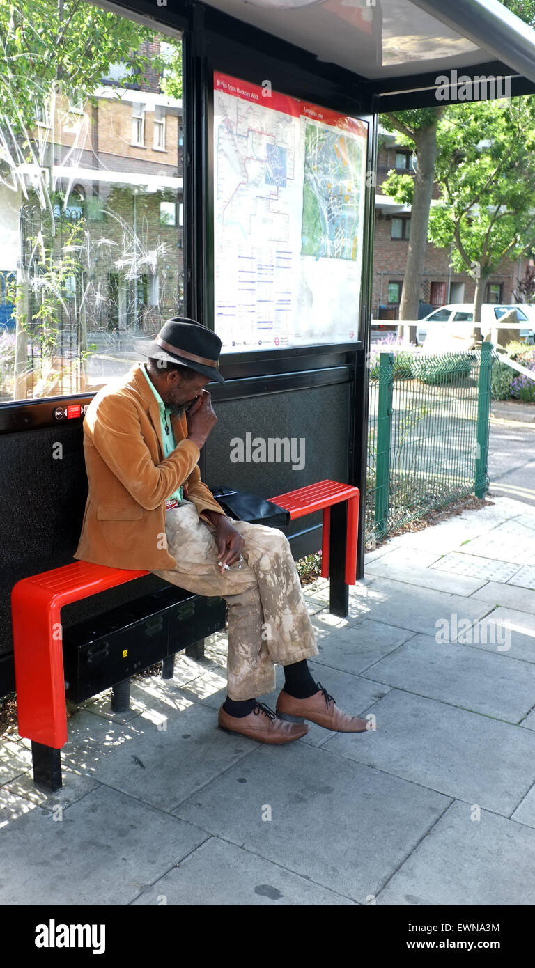 Personnes âgées homme noir assis à l'arrêt de bus Banque D'Images