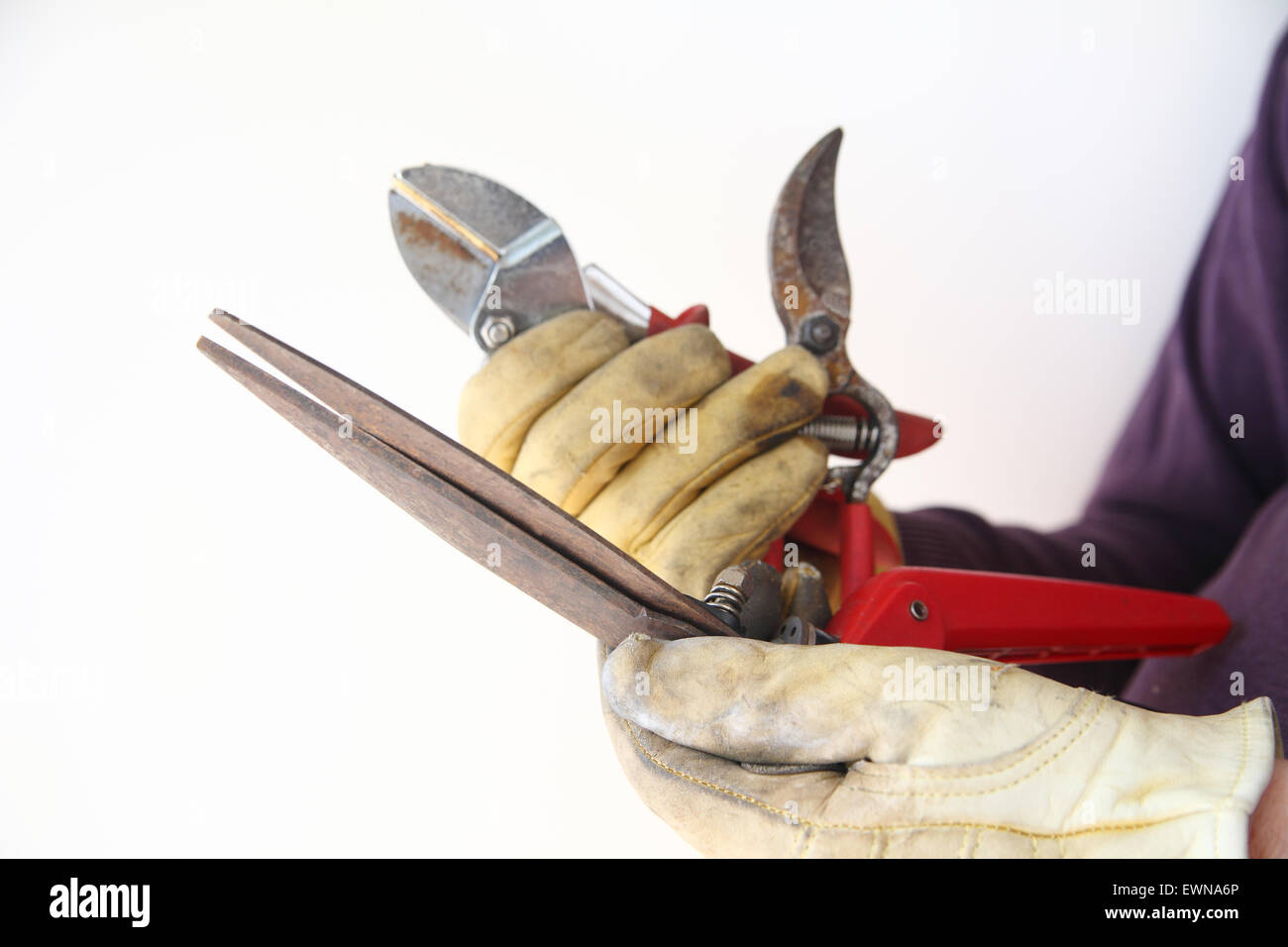 Un ouvrier est utilisé, des outils rouillés dans ses mains gantées. Banque D'Images