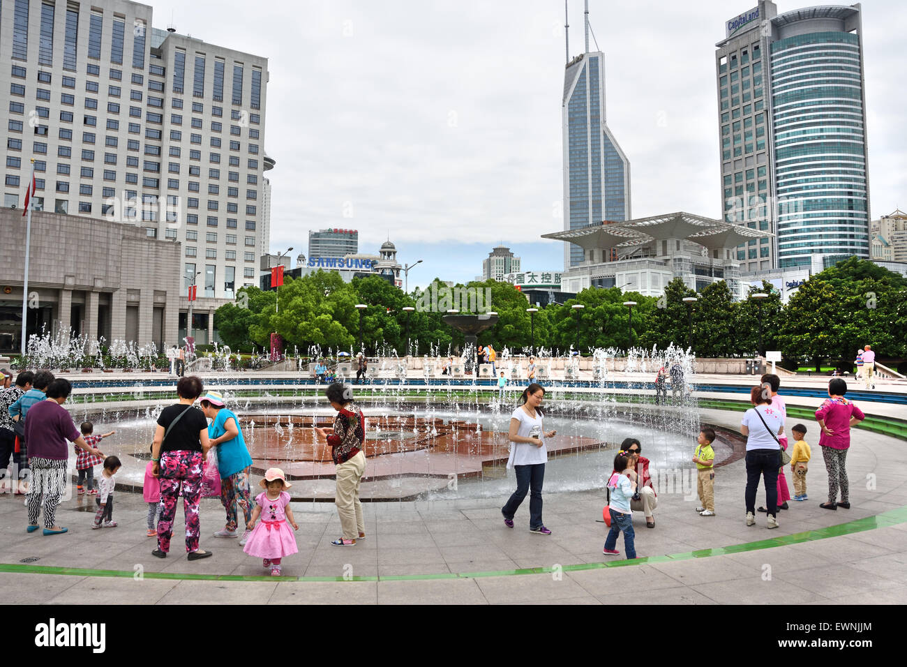 Fontaine avec les gens et les enfants sur la Place du Peuple le gouvernement municipal de la ville de Shanghai Chine Bâtiment city skyline Banque D'Images