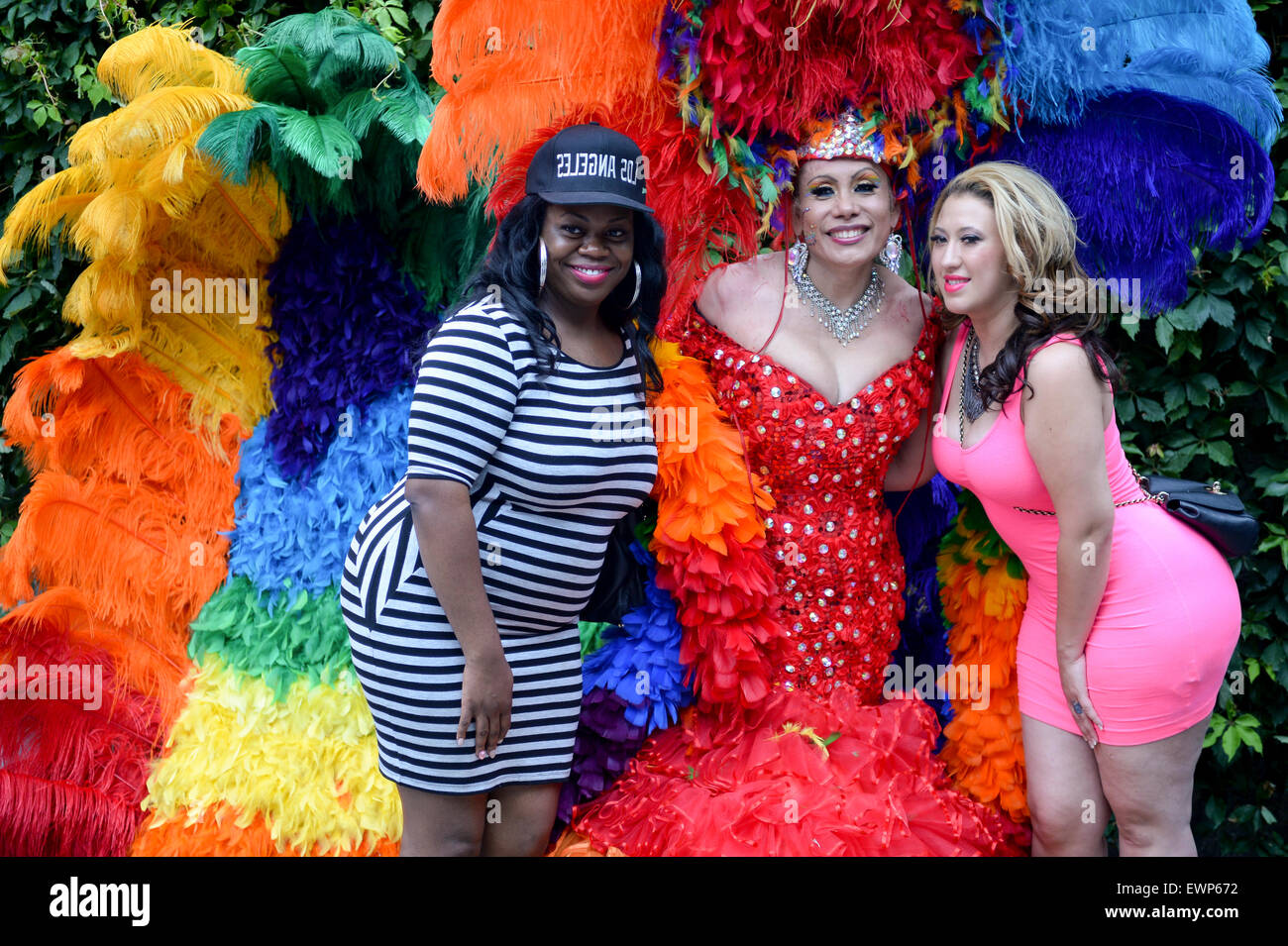 La VILLE DE NEW YORK, USA - 30 juin 2013 : drag queen en costume flamboyant pose pour une photo avec des femmes au cours de la Gay Pride annuelle. Banque D'Images