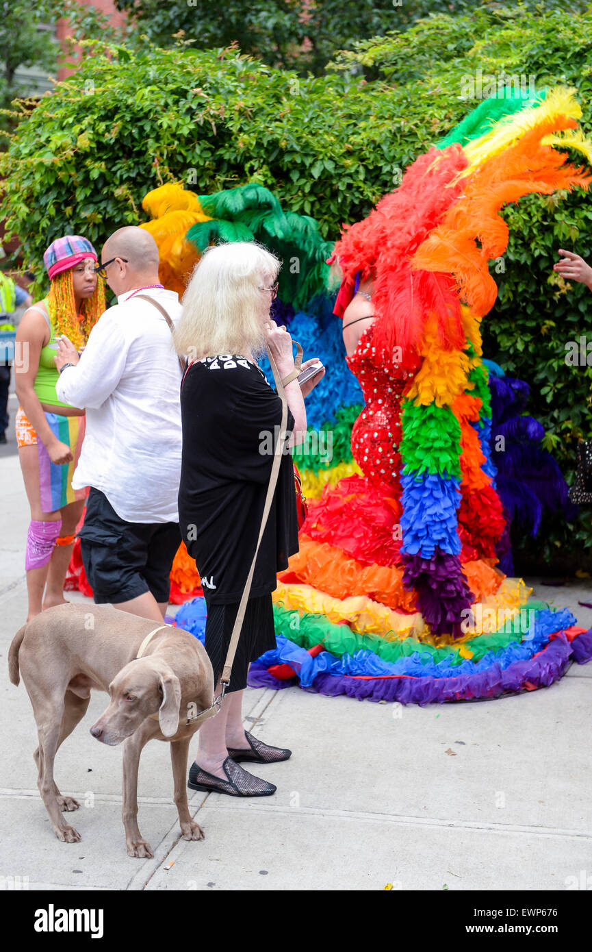 La VILLE DE NEW YORK, USA - 30 juin 2013 : un chien marche avec son propriétaire passé Drag Queens en costumes spectaculaires au cours de la gay pride parade Banque D'Images