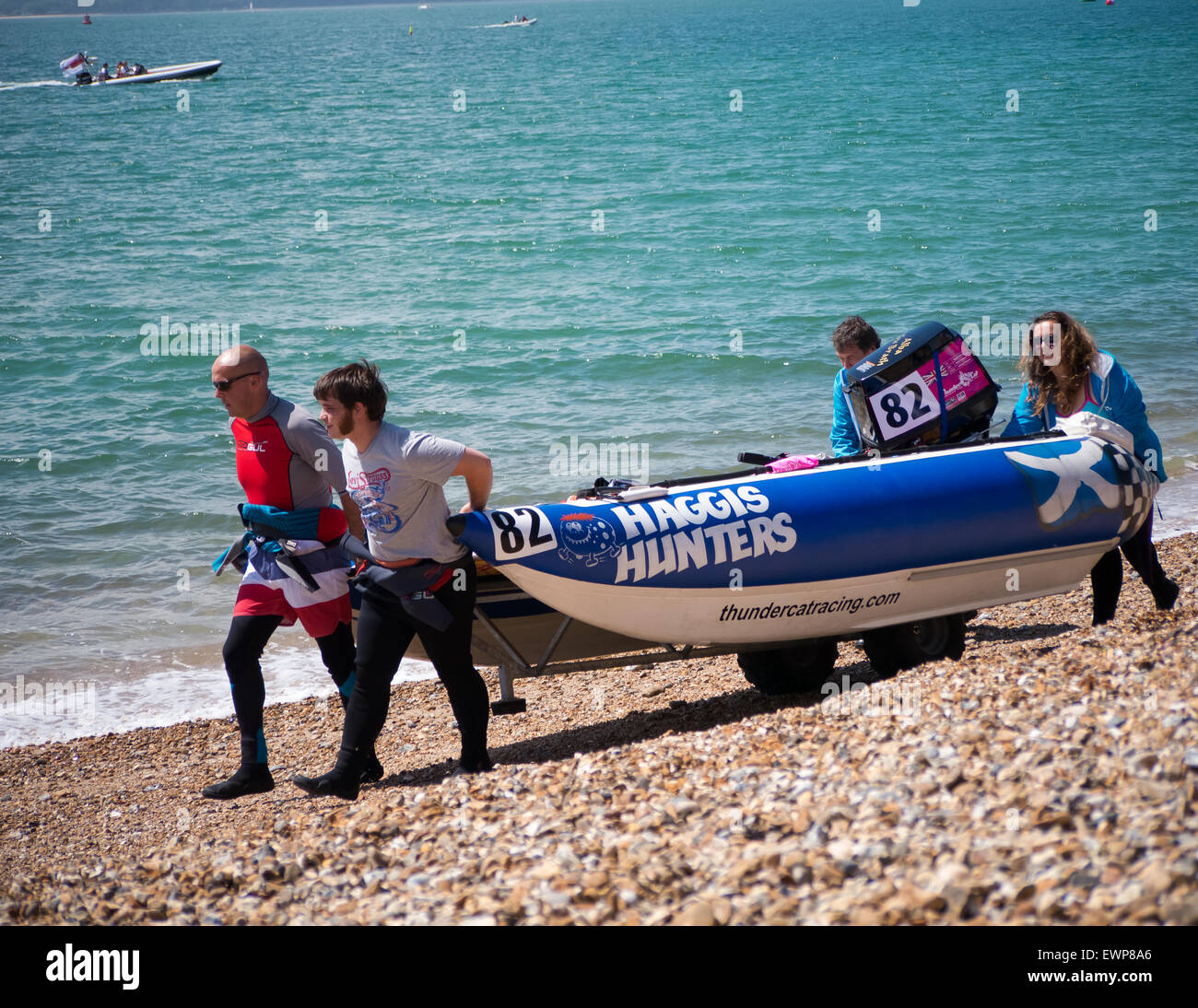Équipage de bateau, porter leur catamaran gonflable rigide avant une course de bateau de puissance le 5ème prb mis à l'dans le Solent Banque D'Images