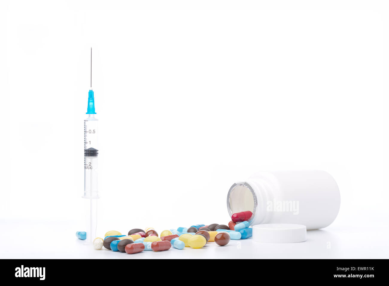 Seringue et pilules colorées avec une bouteille ouverte de la médecine Banque D'Images