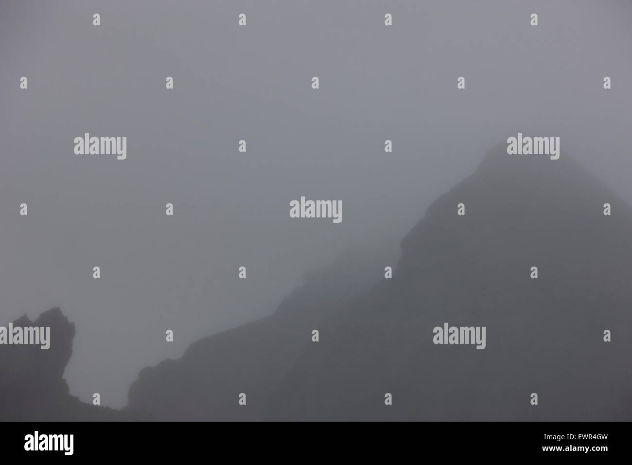 Brouillard et de nuages bas visibilité limitée dans les montagnes avec des visages de troll dans la roche l'Islande Banque D'Images
