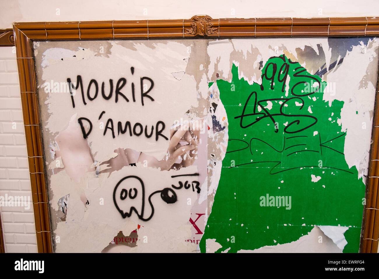 Restes d'affiches publicitaires et artistes graffiti tag sur mur à la gare de métro.Paris,France,Paris,France French Banque D'Images