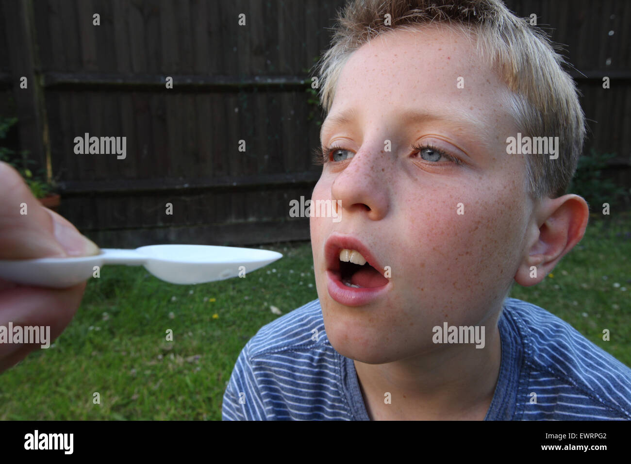 Un garçon en tenant antihistaminique médicament pour aider les symptômes de la fièvre des foins et les allergies Banque D'Images