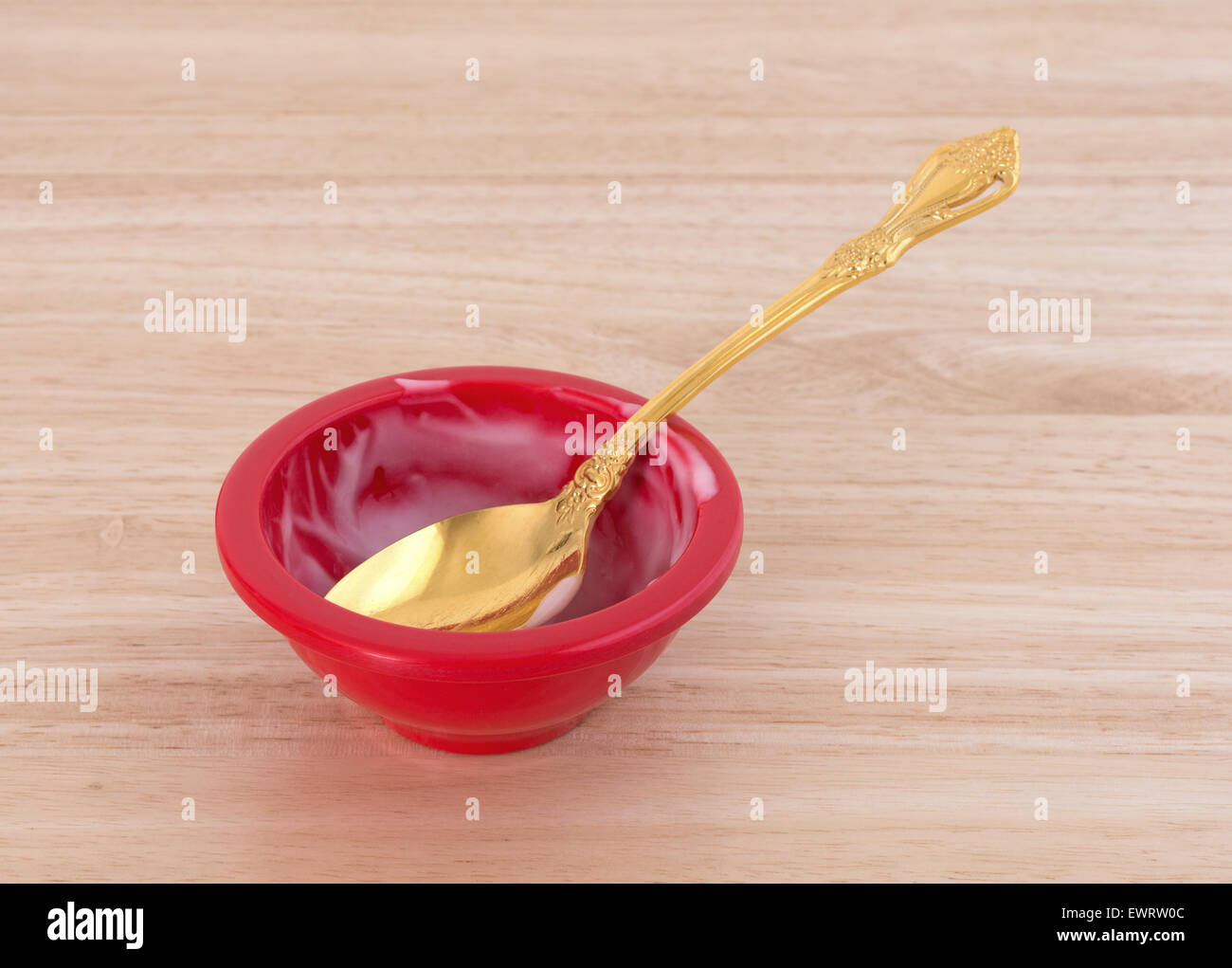 Vue latérale d'un bol de yogourt fraise fini avec une coupe d'or sur un comptoir en bois. Banque D'Images