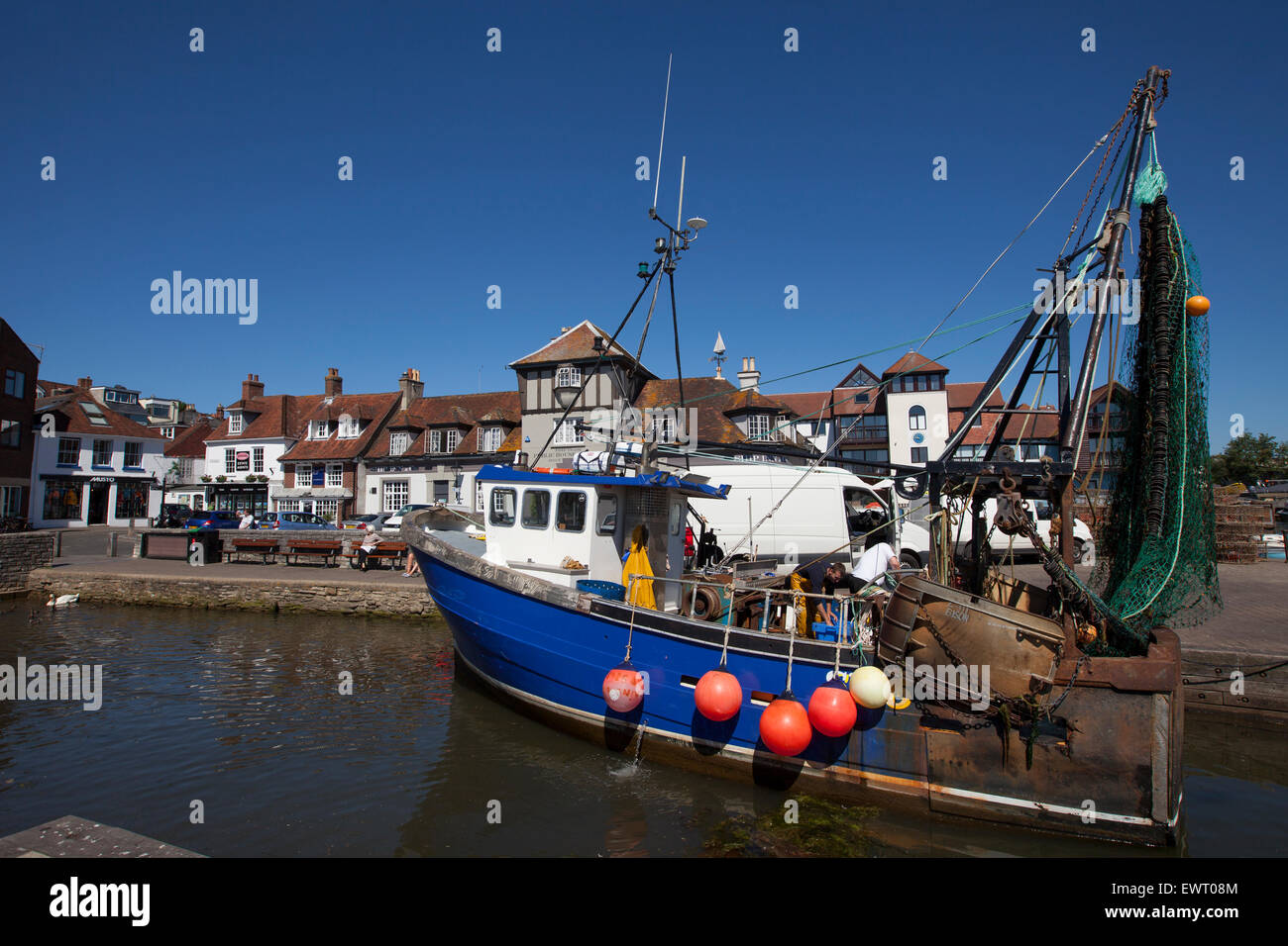 Chalutier de pêche, représenté à Lymington Quay avec boutiques et restaurants dans l'arrière-plan Banque D'Images