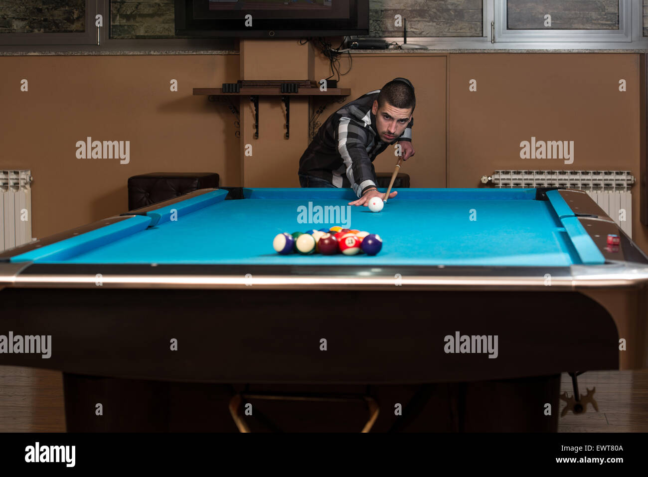 Jeune homme doublure pour balle frappée sur Table de billard Banque D'Images