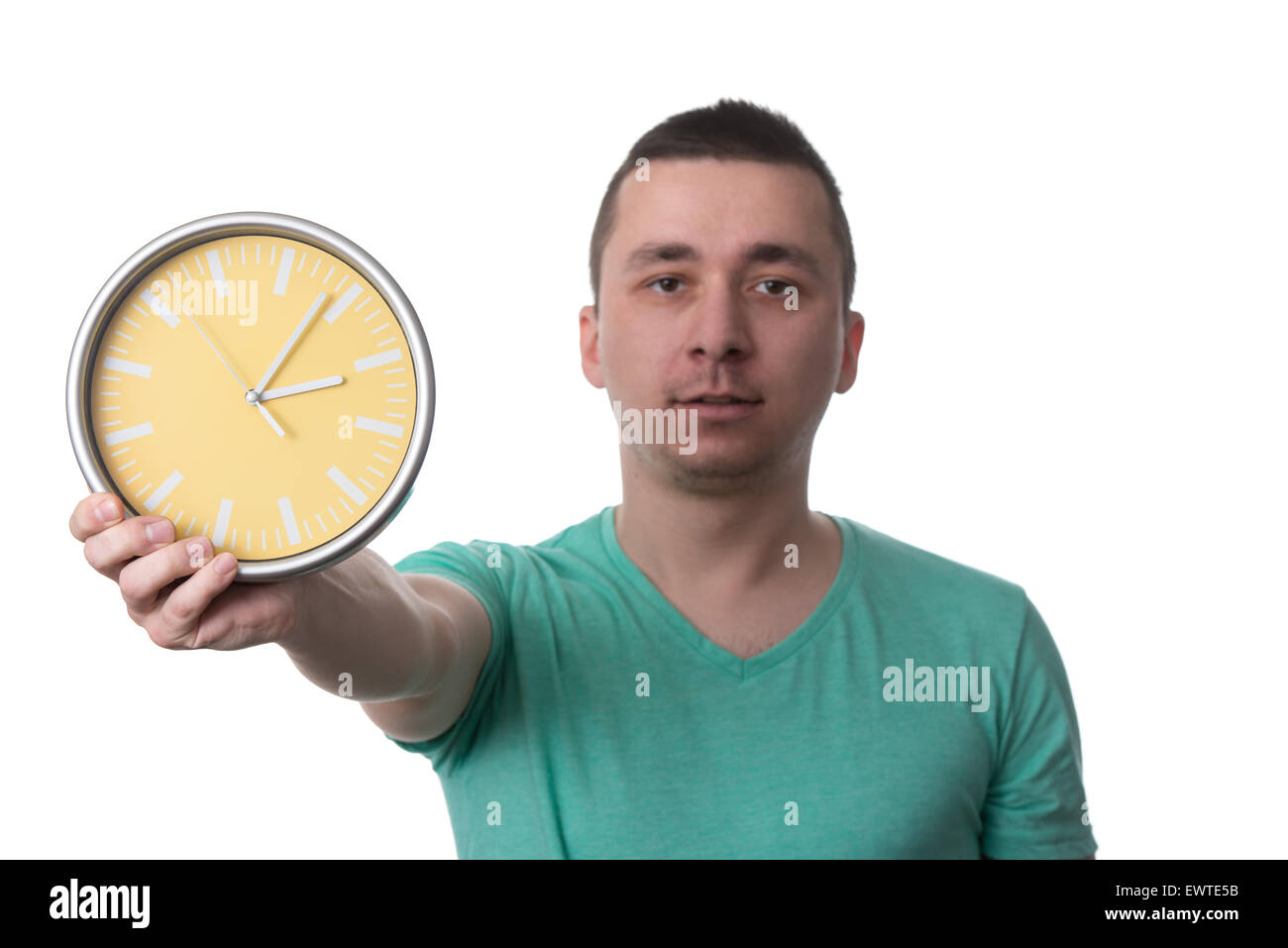 Un homme portant un T-shirt vert et il est titulaire d'un Réveil - plus isolé sur fond blanc Banque D'Images