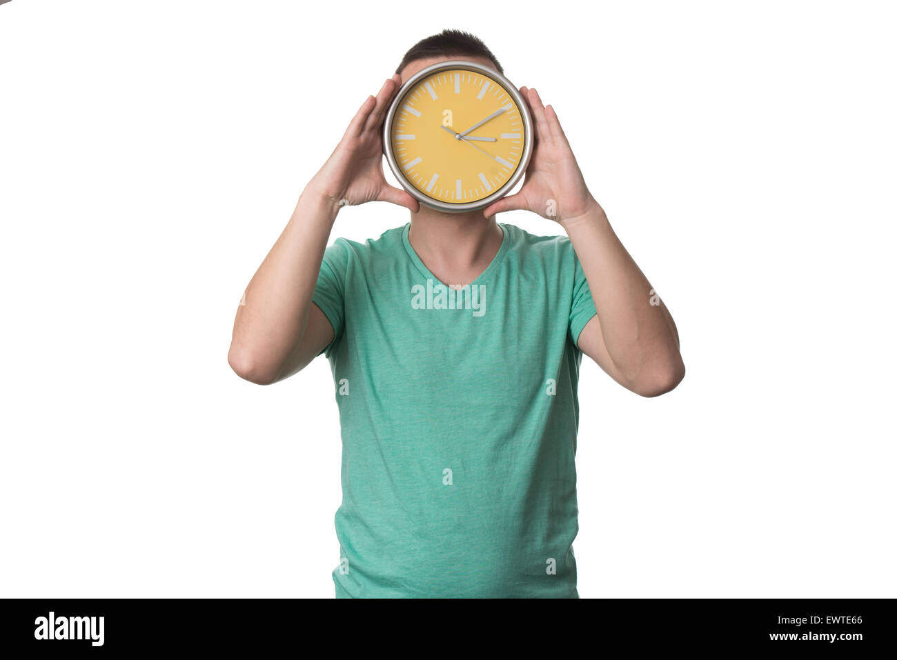 Un homme portant un T-shirt vert et il est titulaire d'un Réveil - Over White Background Banque D'Images