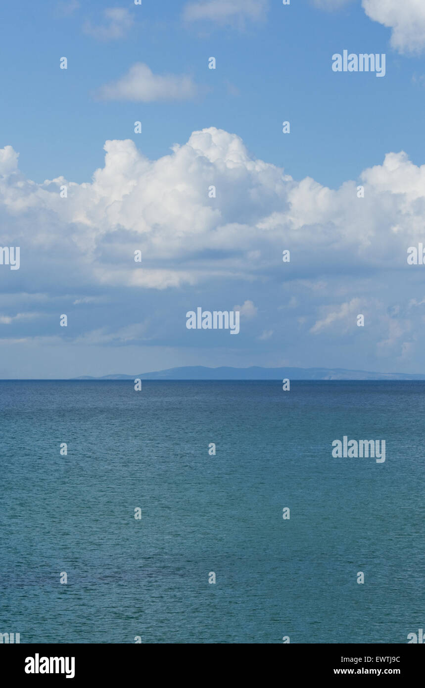Les couleurs pastel des eaux limpides de la mer Egée et nuages dans le ciel et sur l'île de saint (agios efstratios) sur la ligne d'horizon Banque D'Images