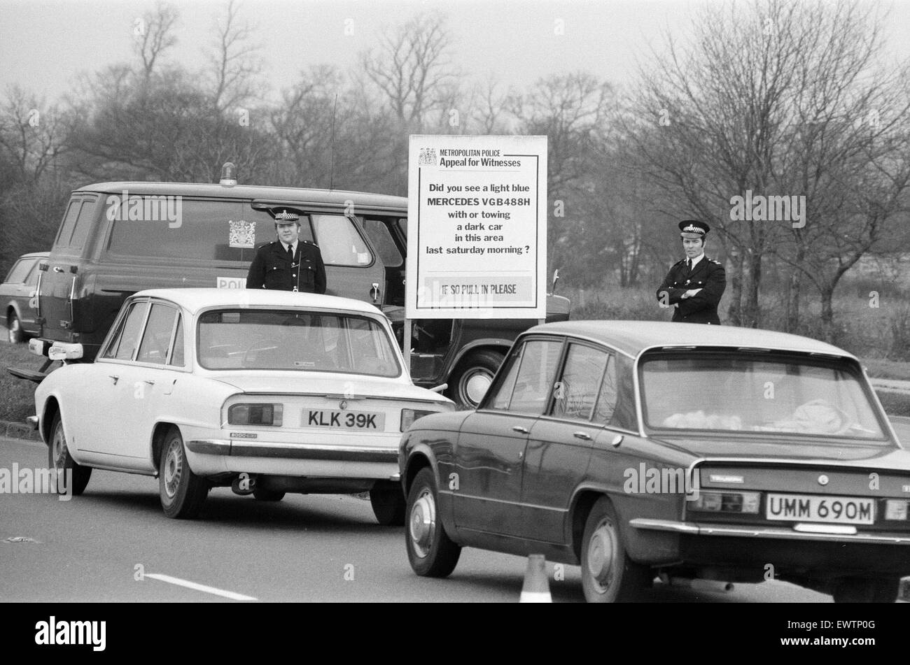 Blocs sur une route de police127 Southend Road, demander aux automobilistes de les aider dans leur enquête sur la disparition de l'entrepreneur de transport George Brett et son fils Terry Brett âgés de 10 ans, qui ont disparu dans de mystérieuses circonstances. Londres. 11 janvier 1975. Banque D'Images