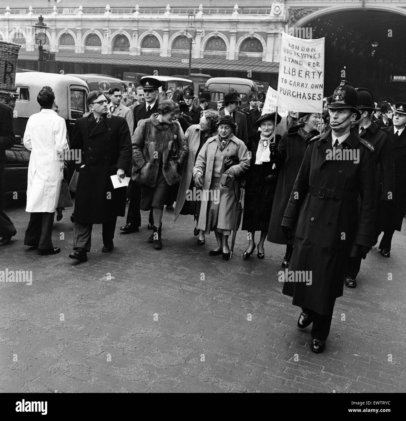 La Ligue des femmes au foyer de Londres a envoyé une délégation à Smithfield Meat Market où ils ont été marqué par la Police de la ville dans le bureau du directeur de marché. Une grande foule de travailleurs du marché attendu à l'extérieur du bureau de chanter et applaudir. 20 janvier 1956. Banque D'Images