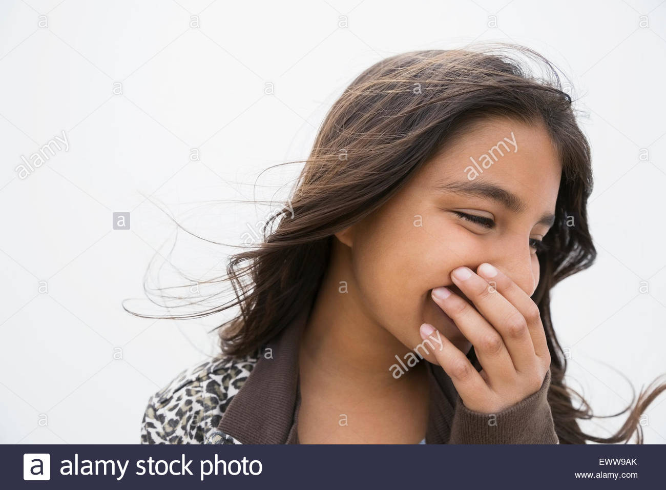 Brunette girl laughing couvrant la bouche avec la main Banque D'Images