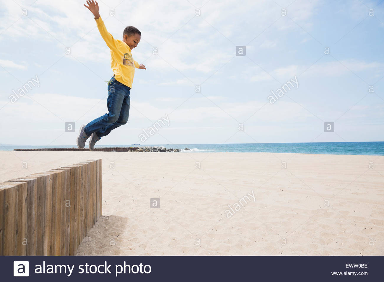 Garçon sautant de plage mur Banque D'Images