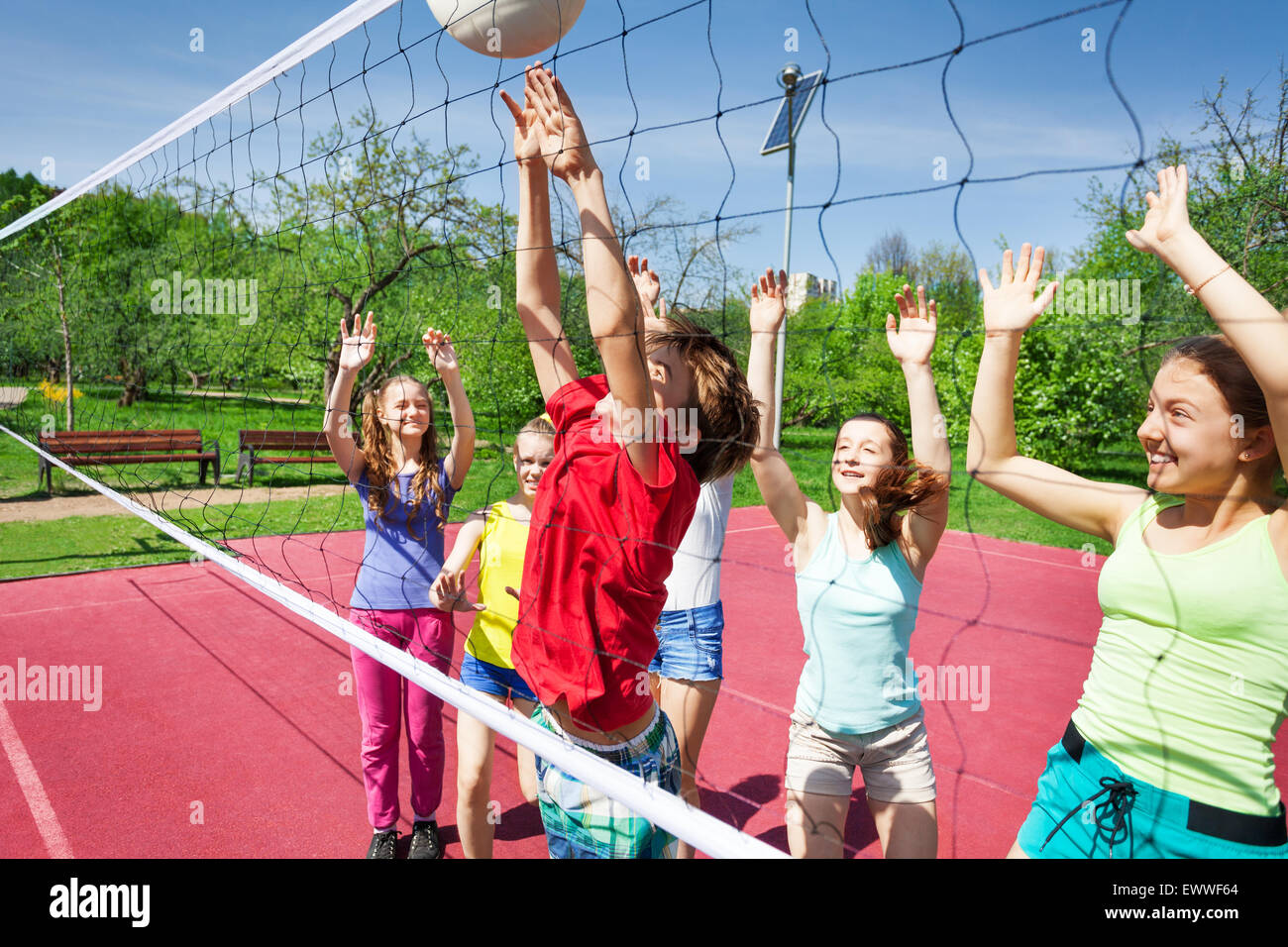 Professionnels de l'adolescence avec les bras de jouer au volley-ball net près de Banque D'Images