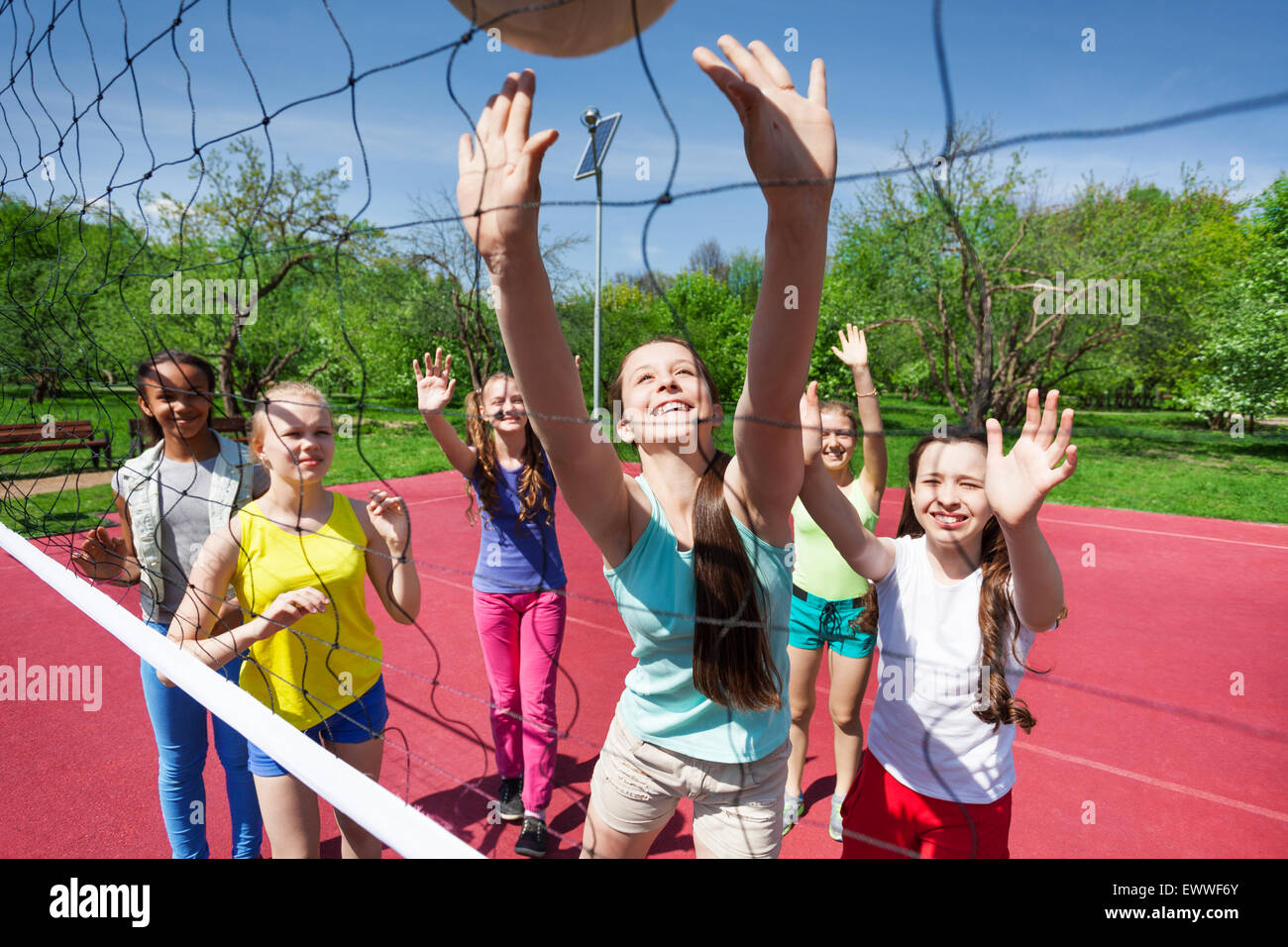 L'équipe d'adolescents jouer au volley-ball sur la cour Banque D'Images