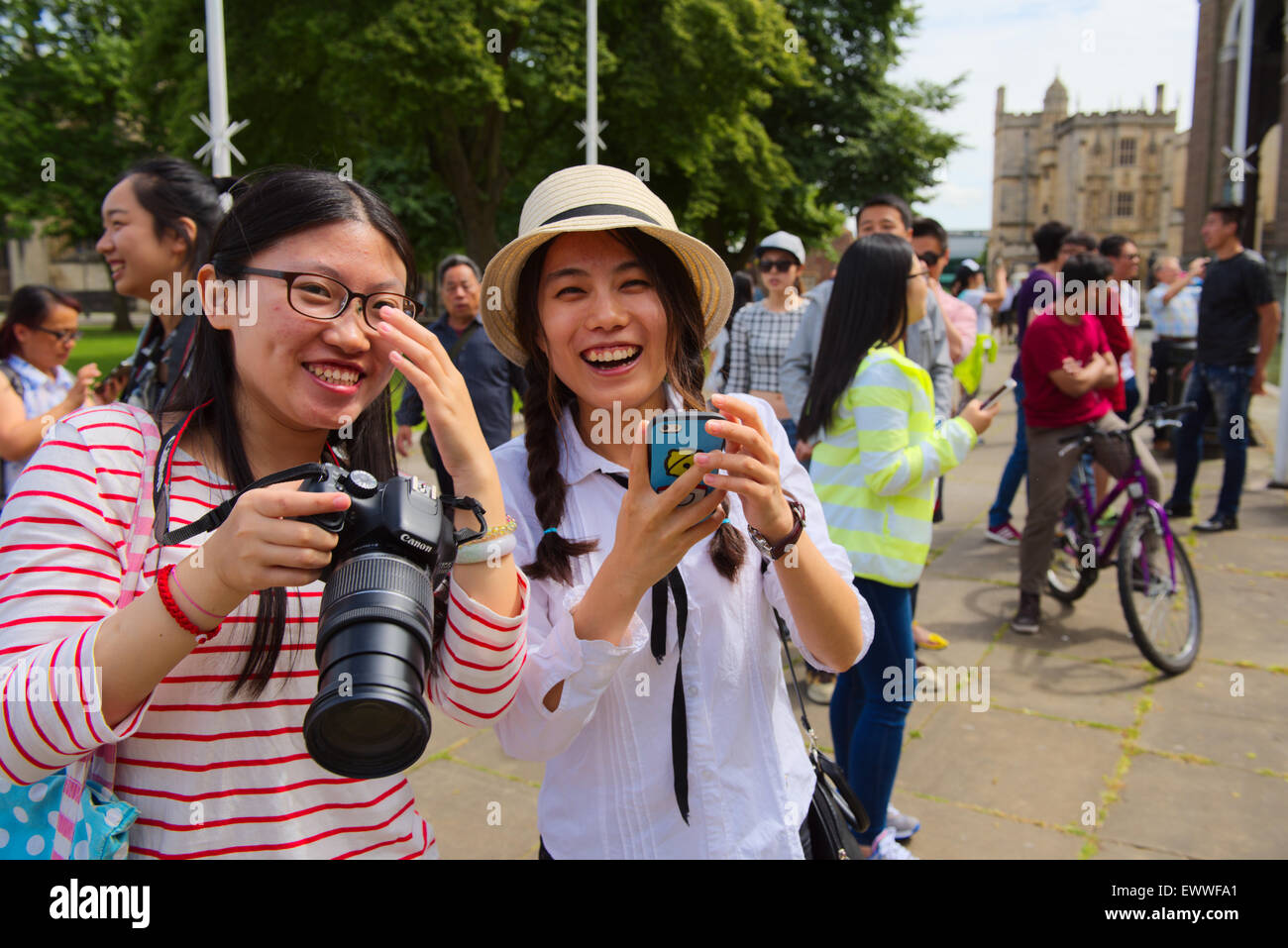 Deux jolies femmes asiatiques avec un appareil photo numérique et d'autres avec téléphone appareil photo à l'extérieur Banque D'Images