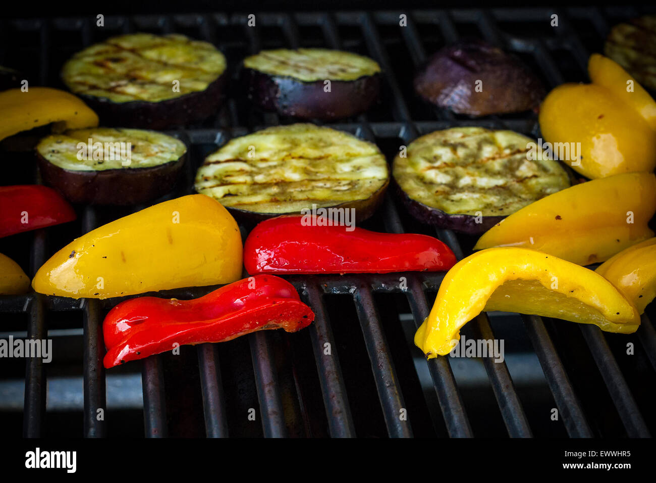 Les tranches d'aubergine, poivrons rouge et jaune sur le gril, soft focus Banque D'Images