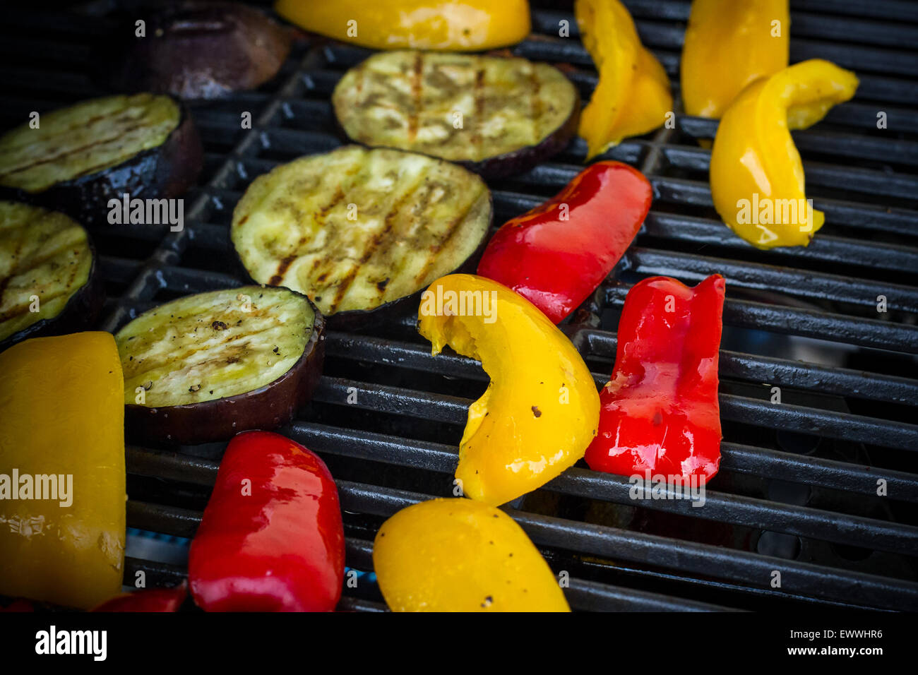 Des poivrons rouges et jaunes, les tranches d'aubergine sur gril, soft focus Banque D'Images