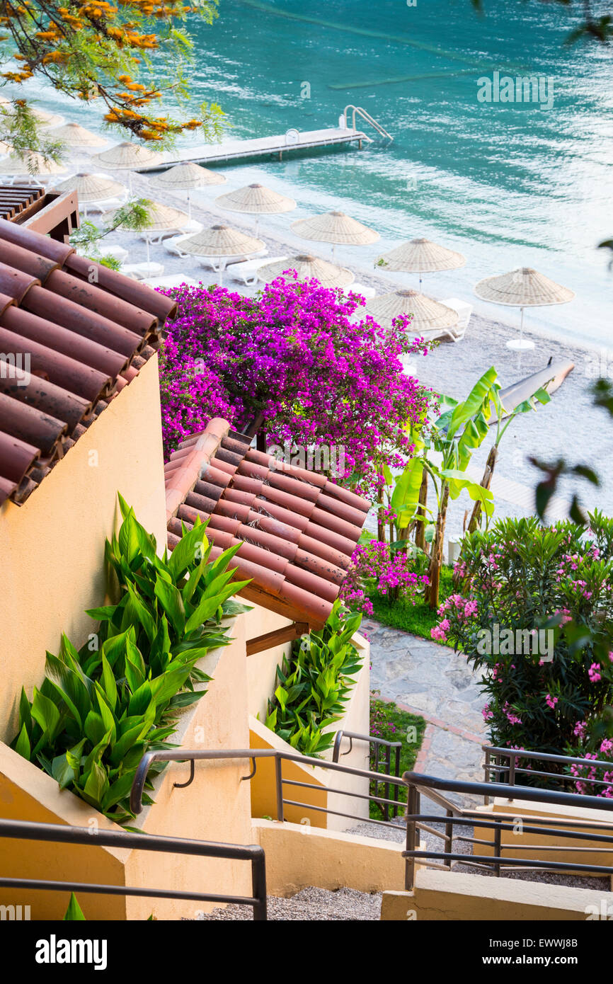 Beach house avec terrasse jardin, à la direction de la plage Parasols et chaises longues près de seaside Banque D'Images