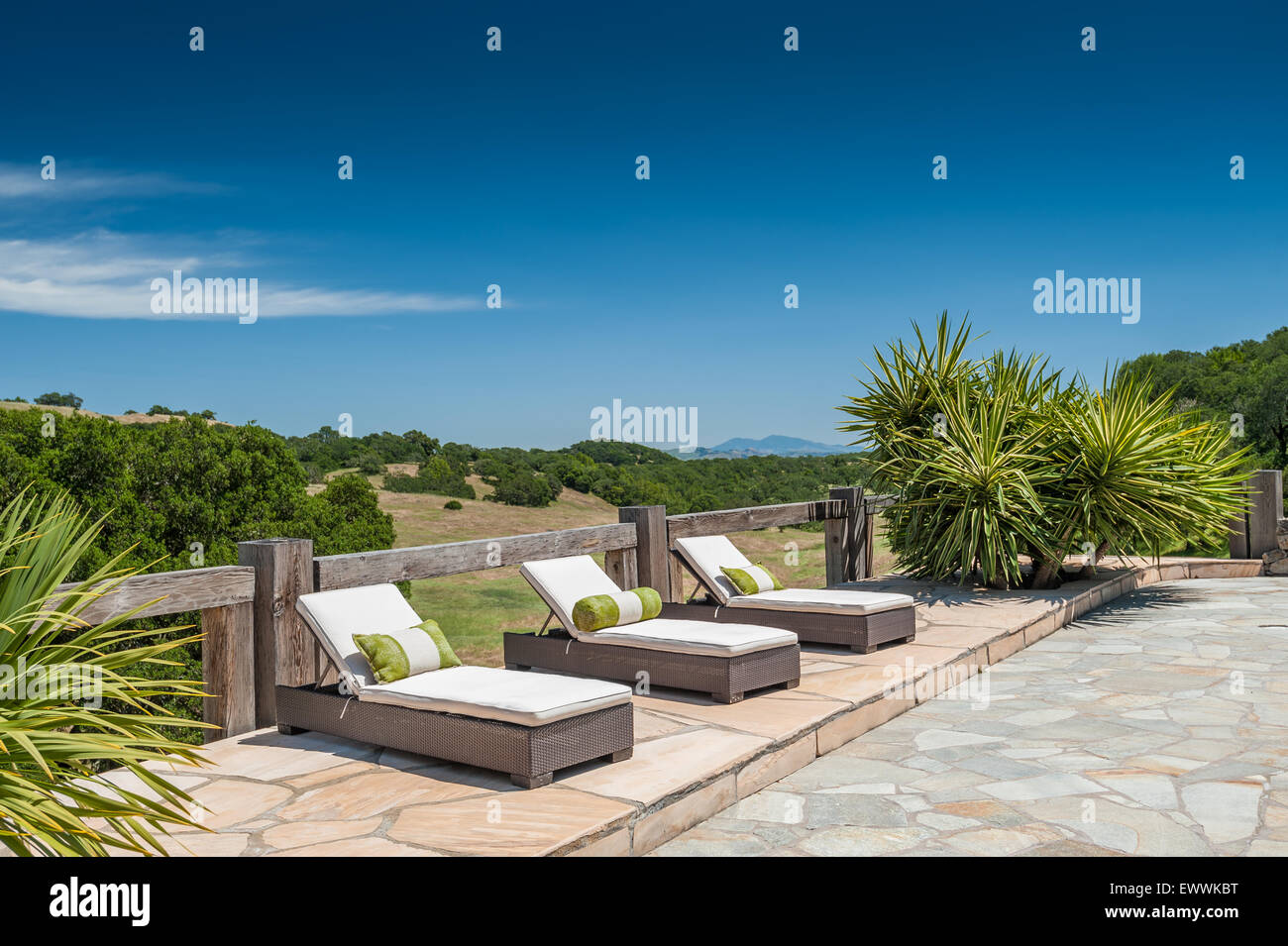 Chaises modernes chaise longue avec coussins sur terrasse dallée Banque D'Images