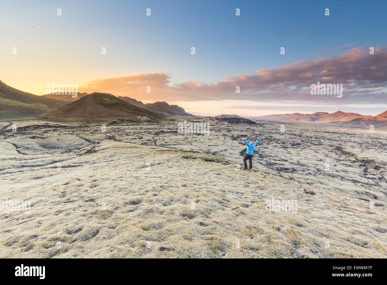L'homme en regardant le coucher de soleil dans un champ de lave en Islande, complètement seul avec lui-même Banque D'Images
