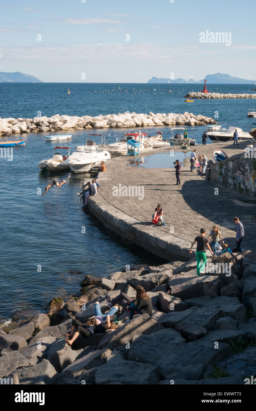 Les gens au soleil près de l'eau à Naples, Italie Banque D'Images