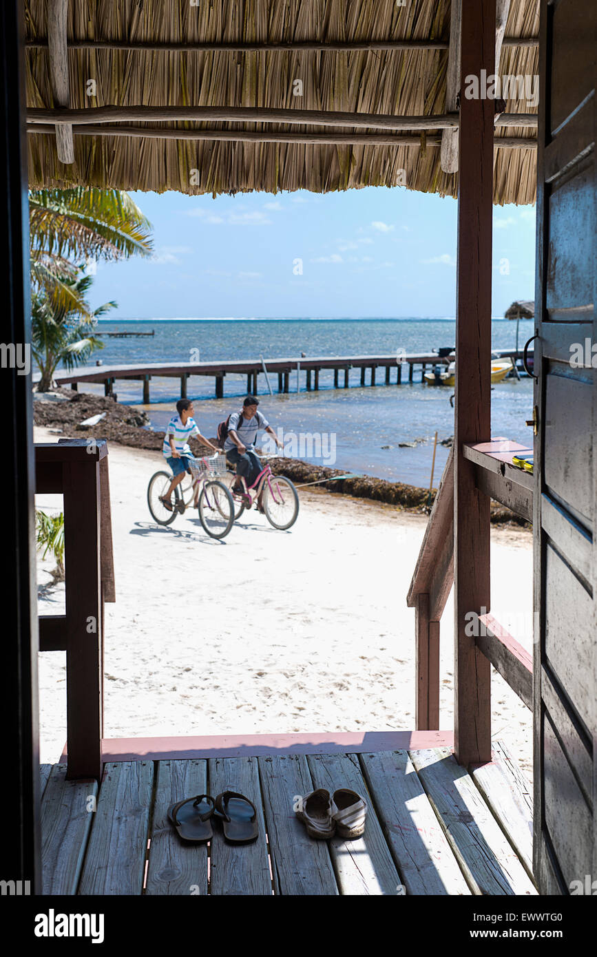 À la recherche d'une porte à deux enfants de la bicyclette à San Pedro, Belize. Banque D'Images