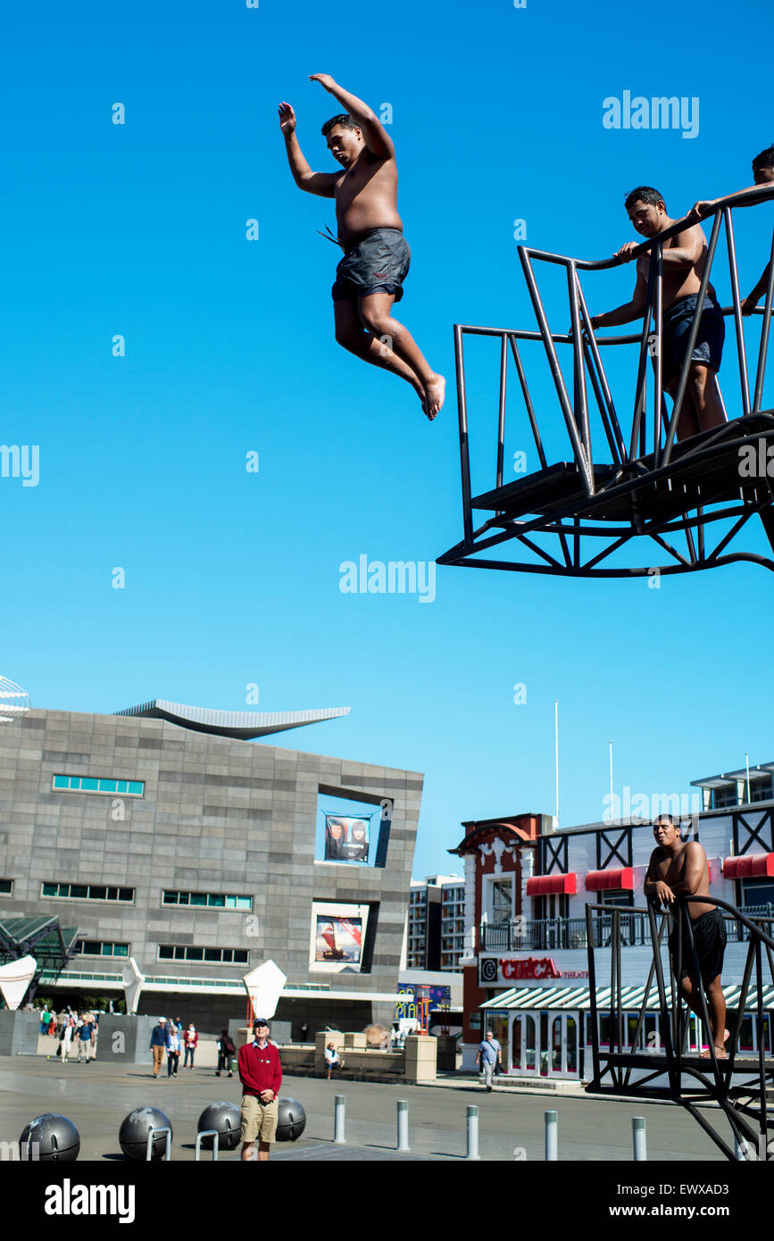 Les jeunes hommes de sauter d'une plate-forme à l'heure du déjeuner à côté de musée national Te Papa à Wellington, Nouvelle-Zélande. Banque D'Images