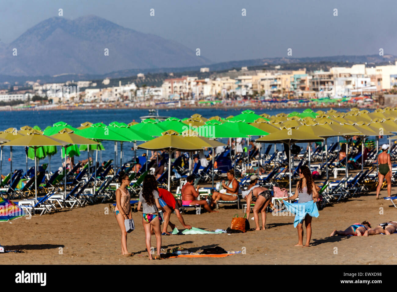 Une foule de gens, touristes se détendant sur la plage de sable Rethymno Crete Beach Grèce plage bains de soleil, vacanciers Banque D'Images