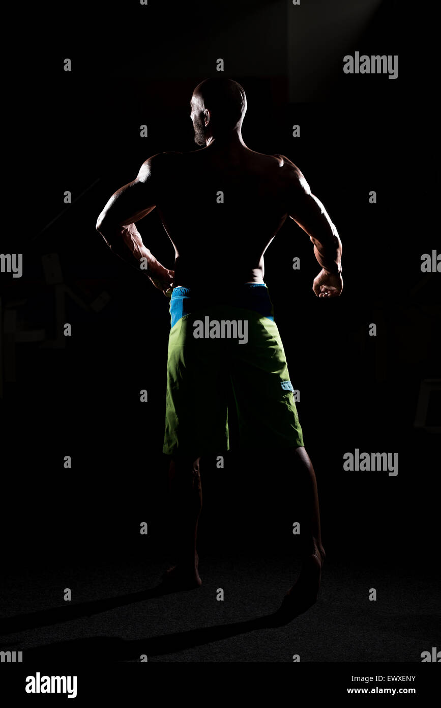 Siluet Man Flexing Muscles musculaire Banque D'Images