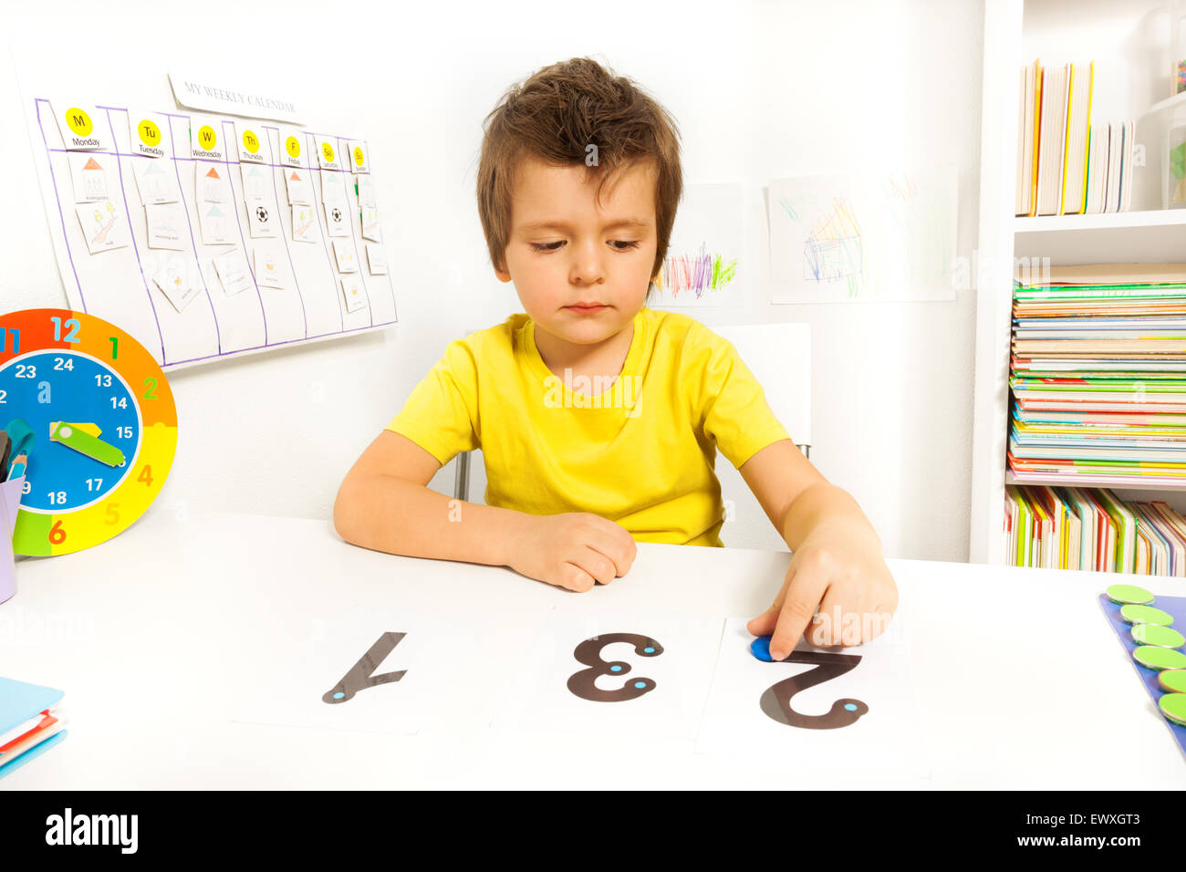 Garçon apprendre à compter mettre des pièces sur le nombre Banque D'Images Garçon apprendre à compter mettre des pièces sur le nombre Banque D'Images