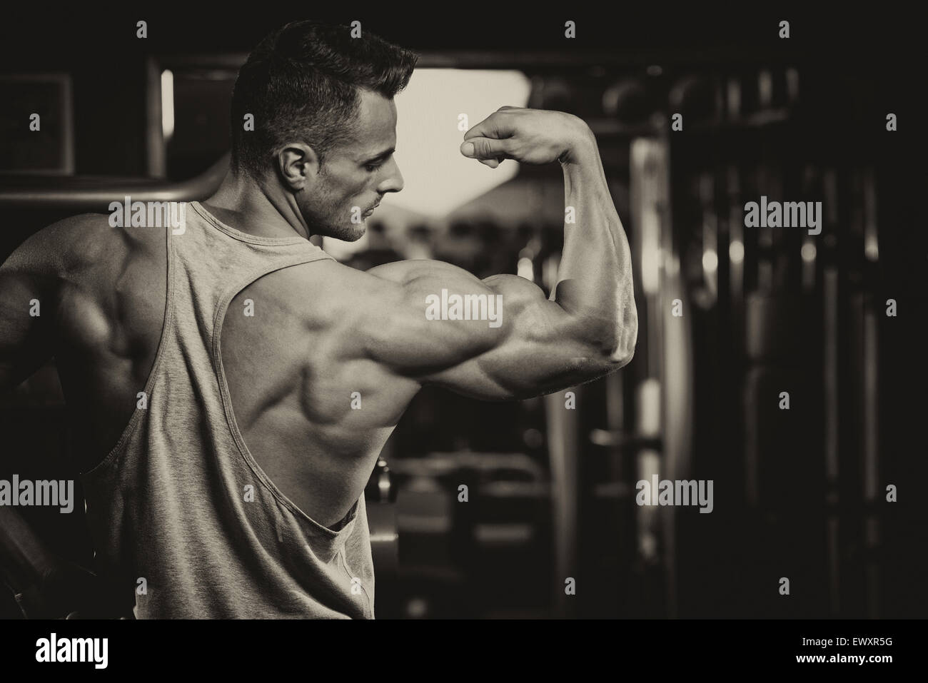 Portrait d'un jeune homme en bonne forme physique - Flexing Muscles Banque D'Images