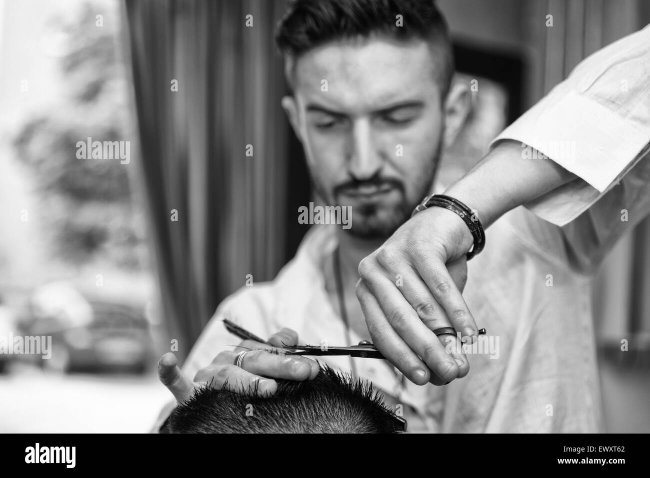 Beau jeune coiffure donnant une nouvelle coupe pour homme Client à Parlour Banque D'Images