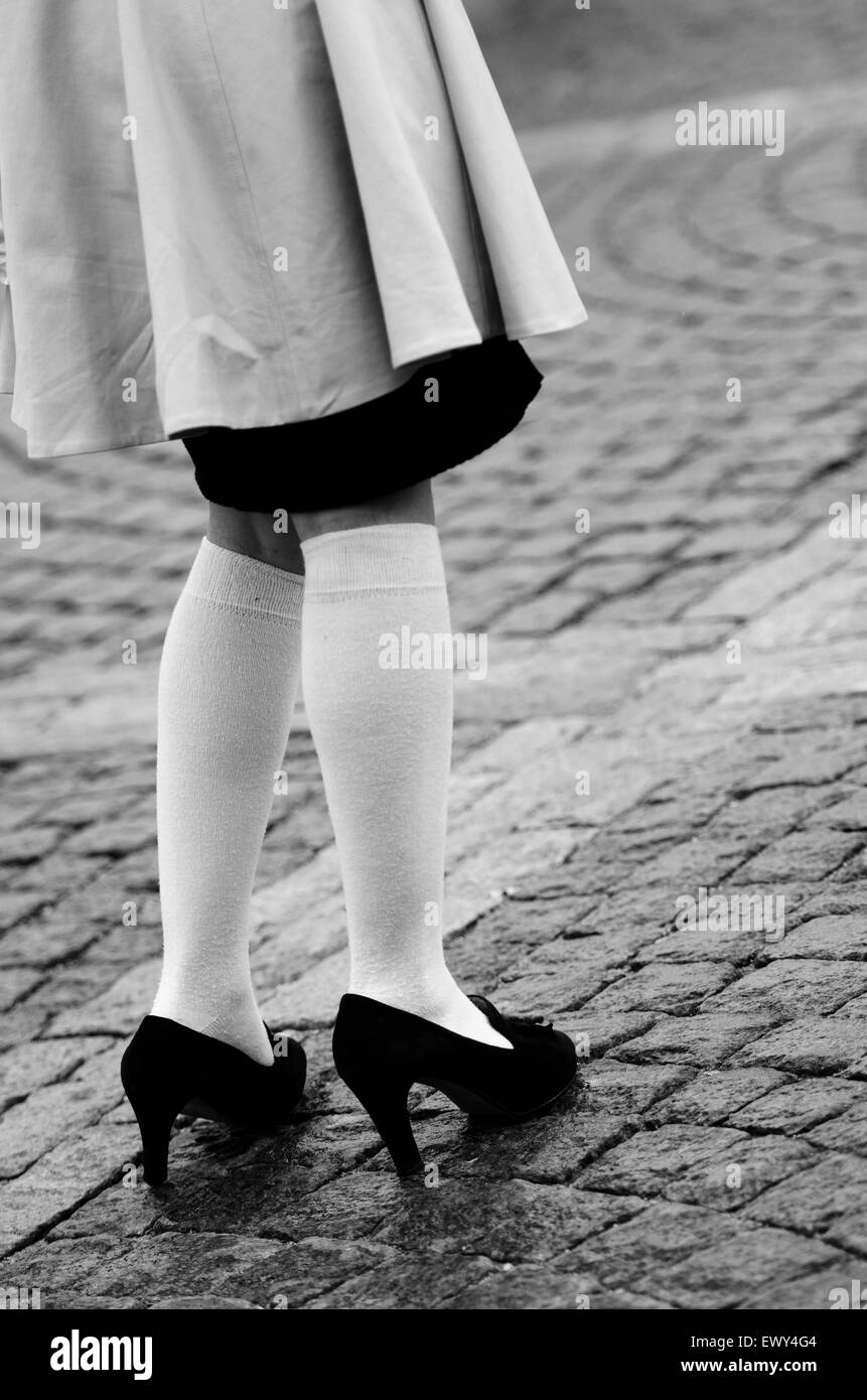 Les jambes des femmes dans des chaussettes et chaussures noires sur le trottoir Banque D'Images