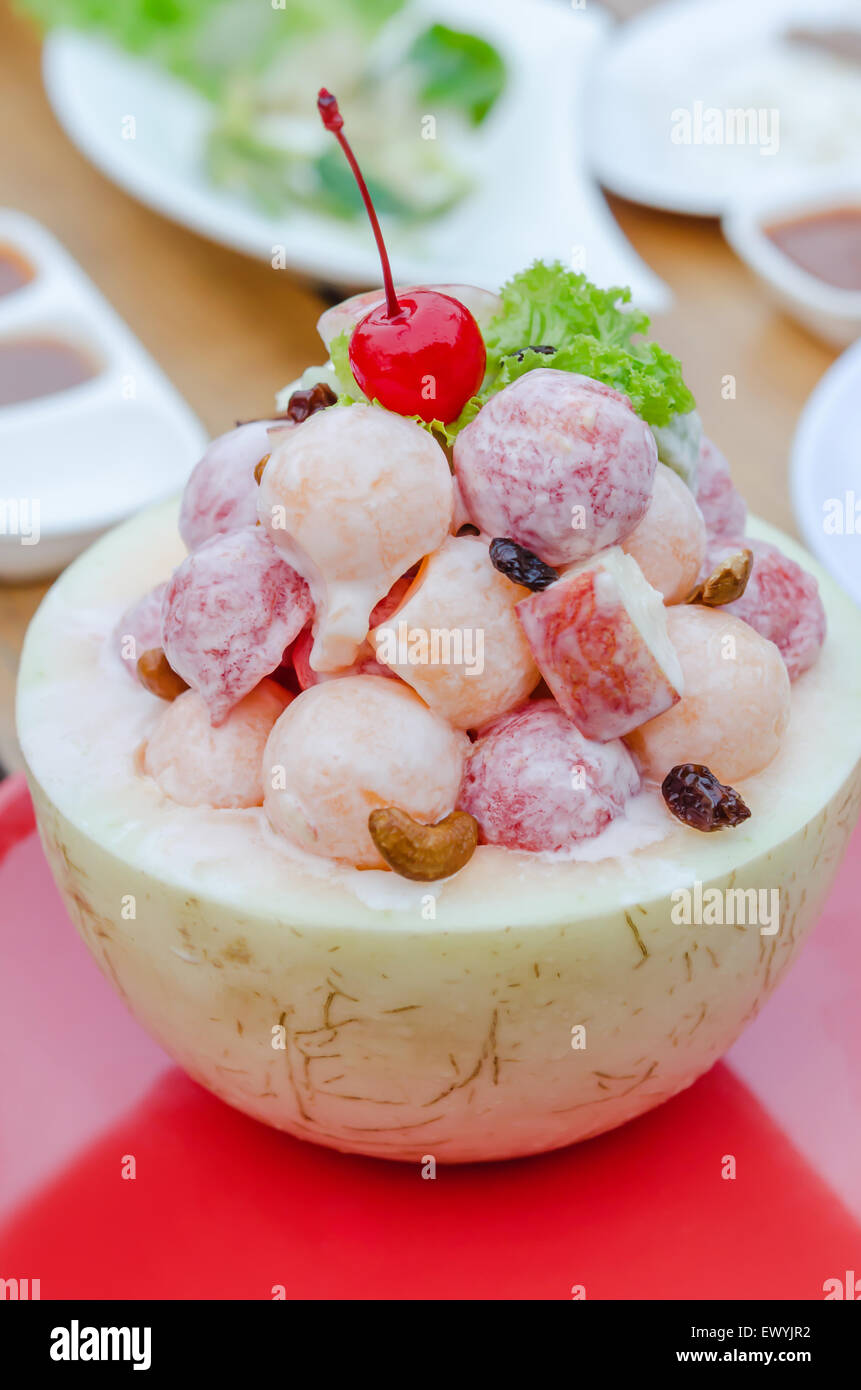 Salade de fruits frais à la crème dans le bol de cantaloup Banque D'Images