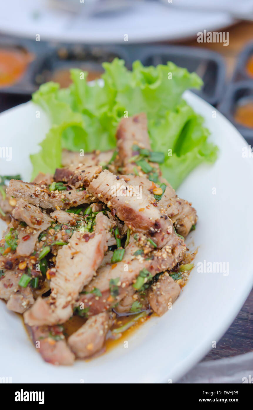 Salade épicée de porc sur un plat blanc Banque D'Images