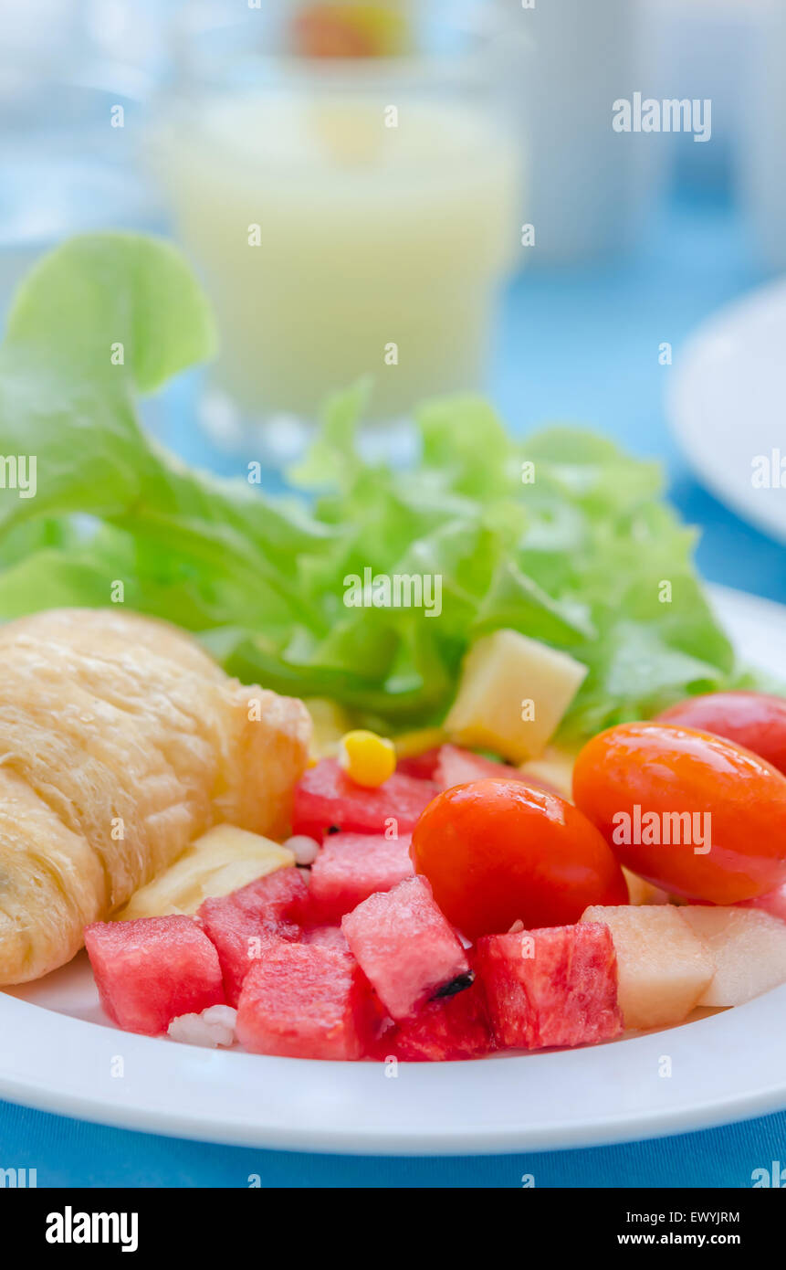 Un petit-déjeuner croissant avec le mélange de salade de fruits Banque D'Images