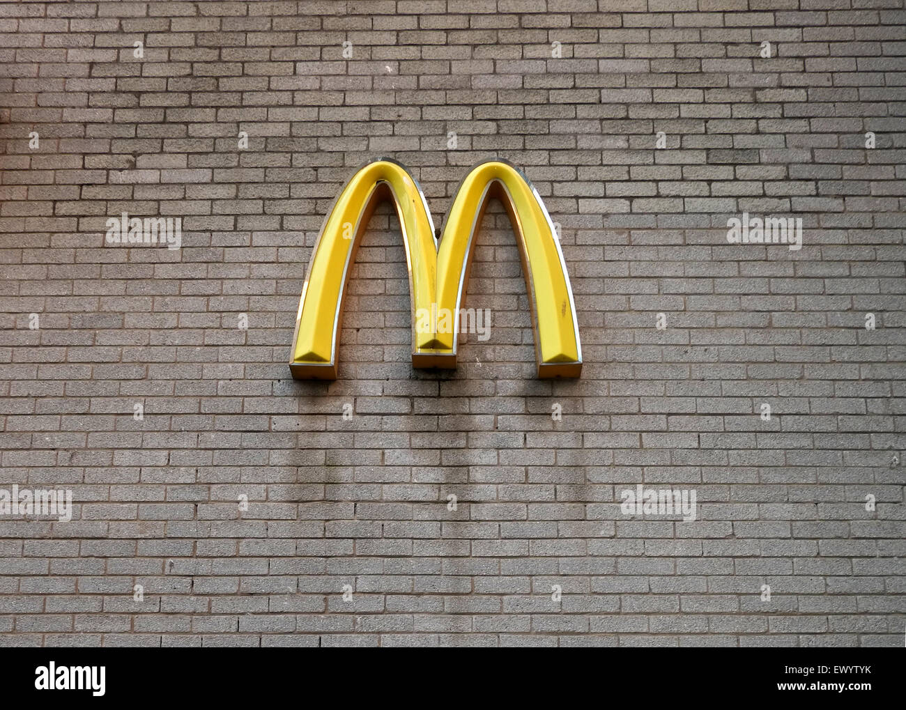 M jaune Mcdonald's signe sur un mur de briques, c'est d'une cour de service derrière un store. Juillet 2015 Banque D'Images