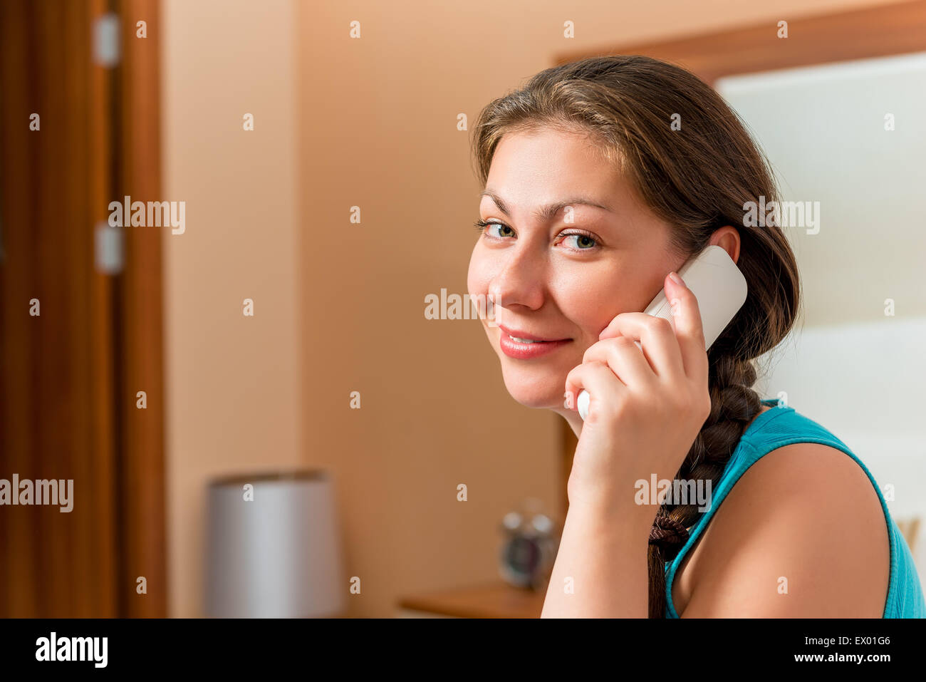 Brunette avec un combiné radio téléphone dans la chambre Banque D'Images