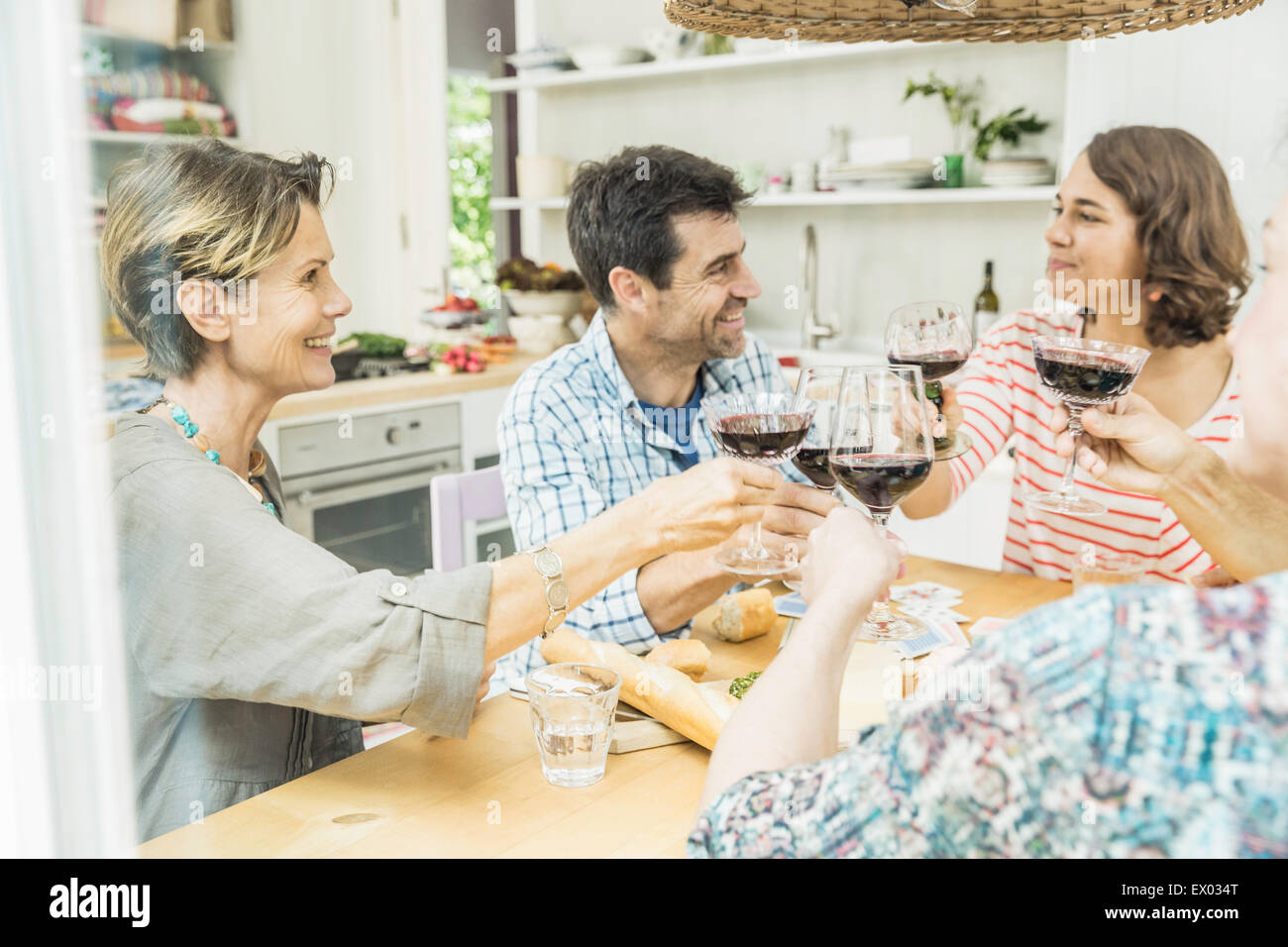 Amis adultes faire un toast avec du vin à table à manger Banque D'Images