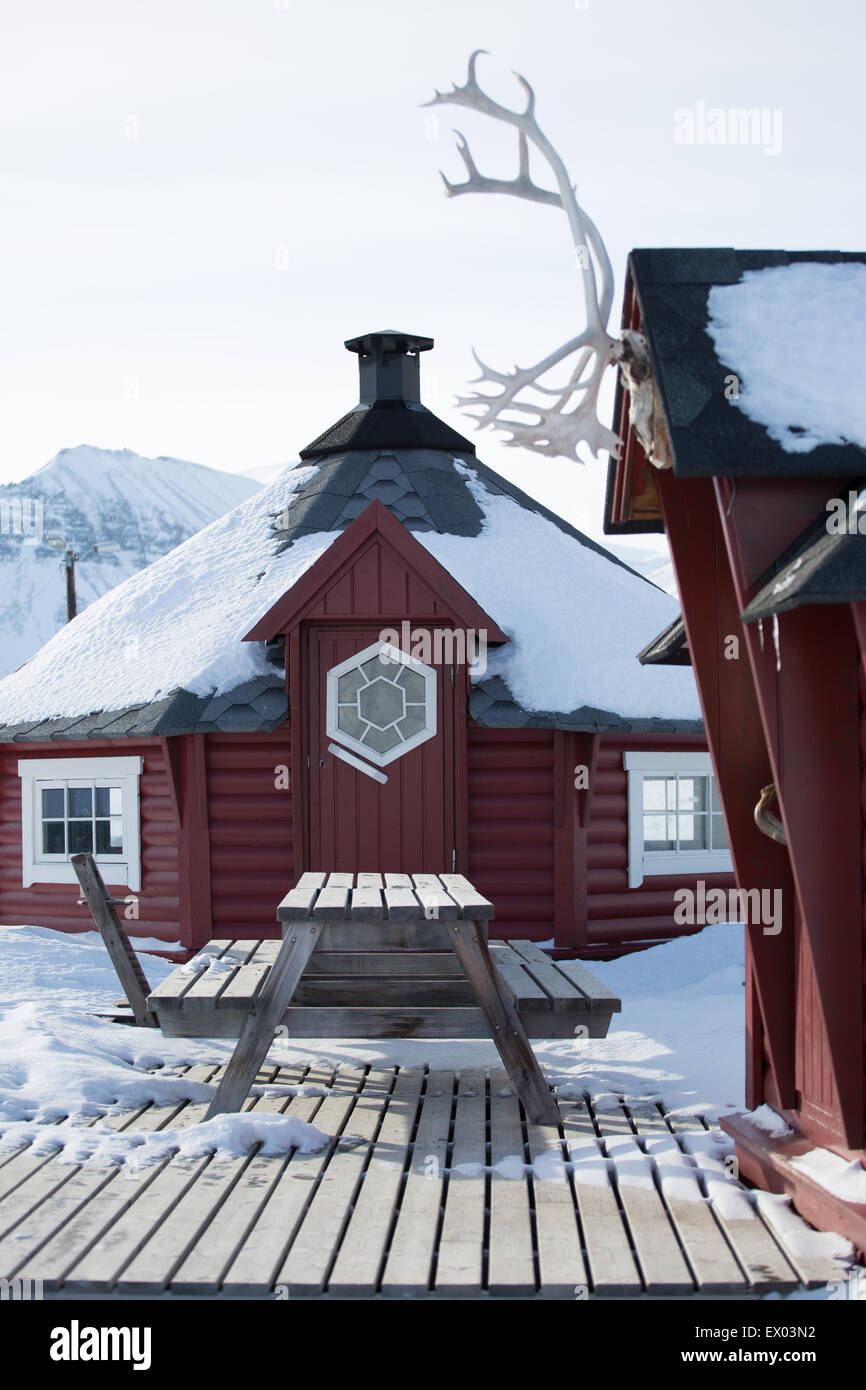 Maison traditionnelle en bois et banc de pique-nique dans la neige, Longyearbyen, Svalbard, Norvège Banque D'Images