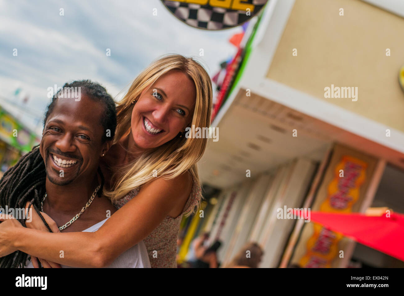 Multi Ethnic woman piggyback partage à amusement park Banque D'Images