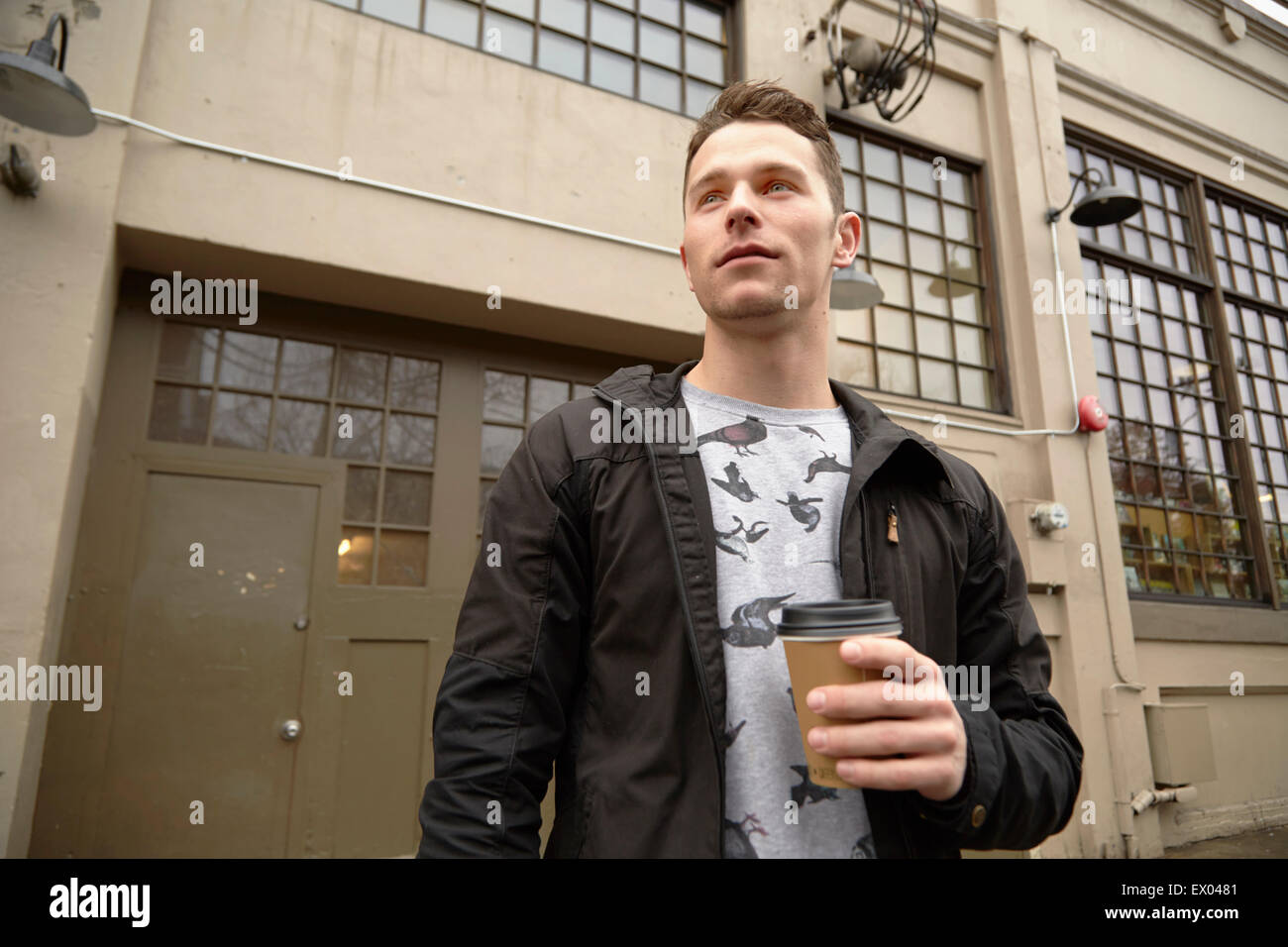 Jeune homme dans la ville de boire du café à emporter Banque D'Images