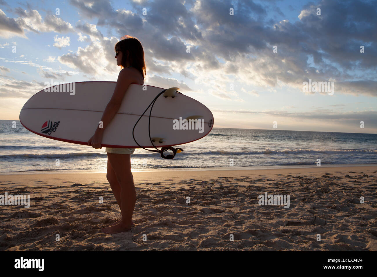 Une jeune fille portant un surf sur Scarborough Beach à Perth, Australie occidentale Banque D'Images