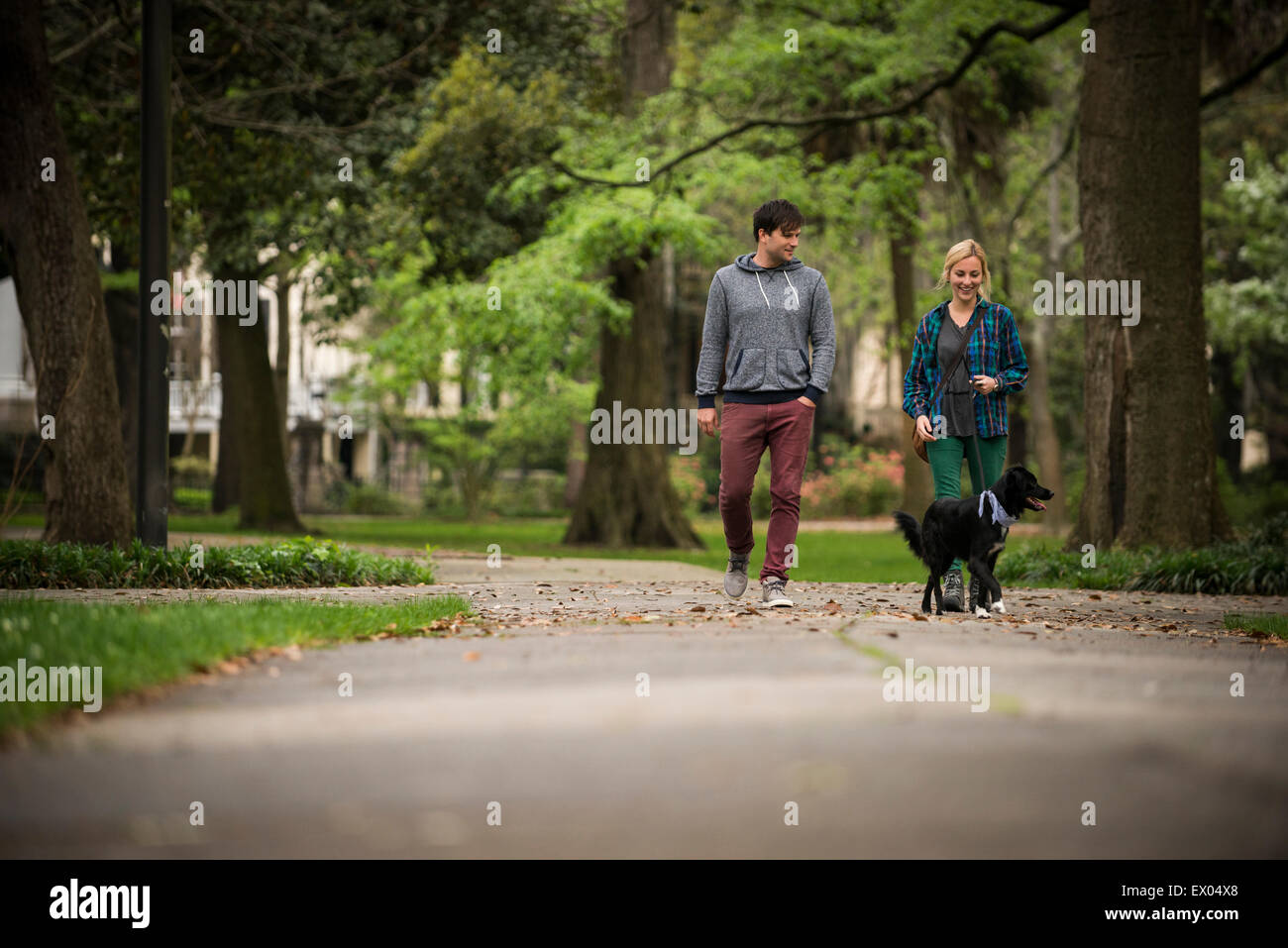 Couple walking dog in park, Savannah, Georgia, USA Banque D'Images