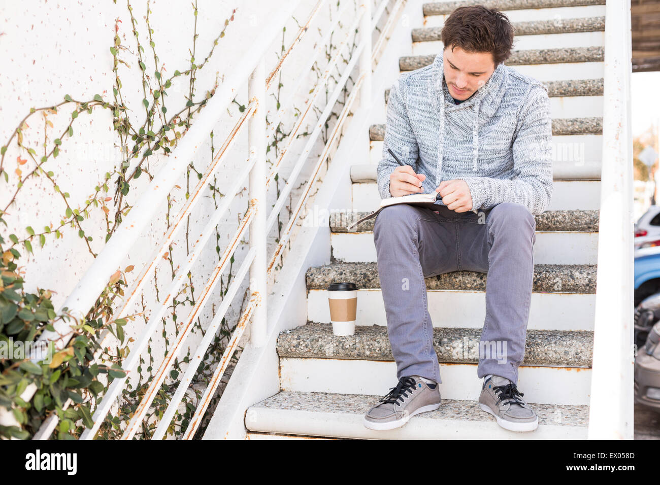Young man sitting on steps écrit Banque D'Images